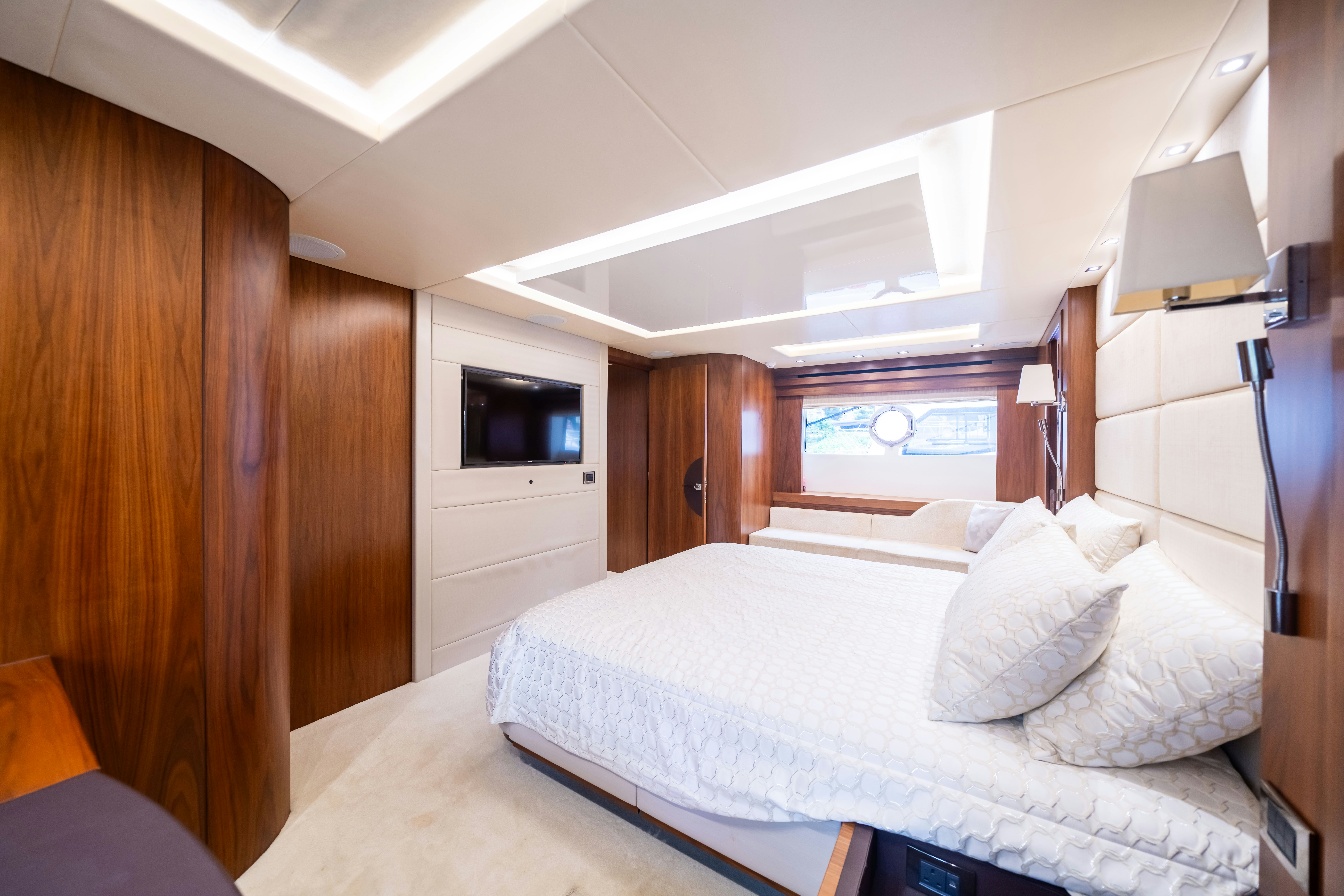 a bedroom with a bed and a television aboard DRAGON Yacht for Sale