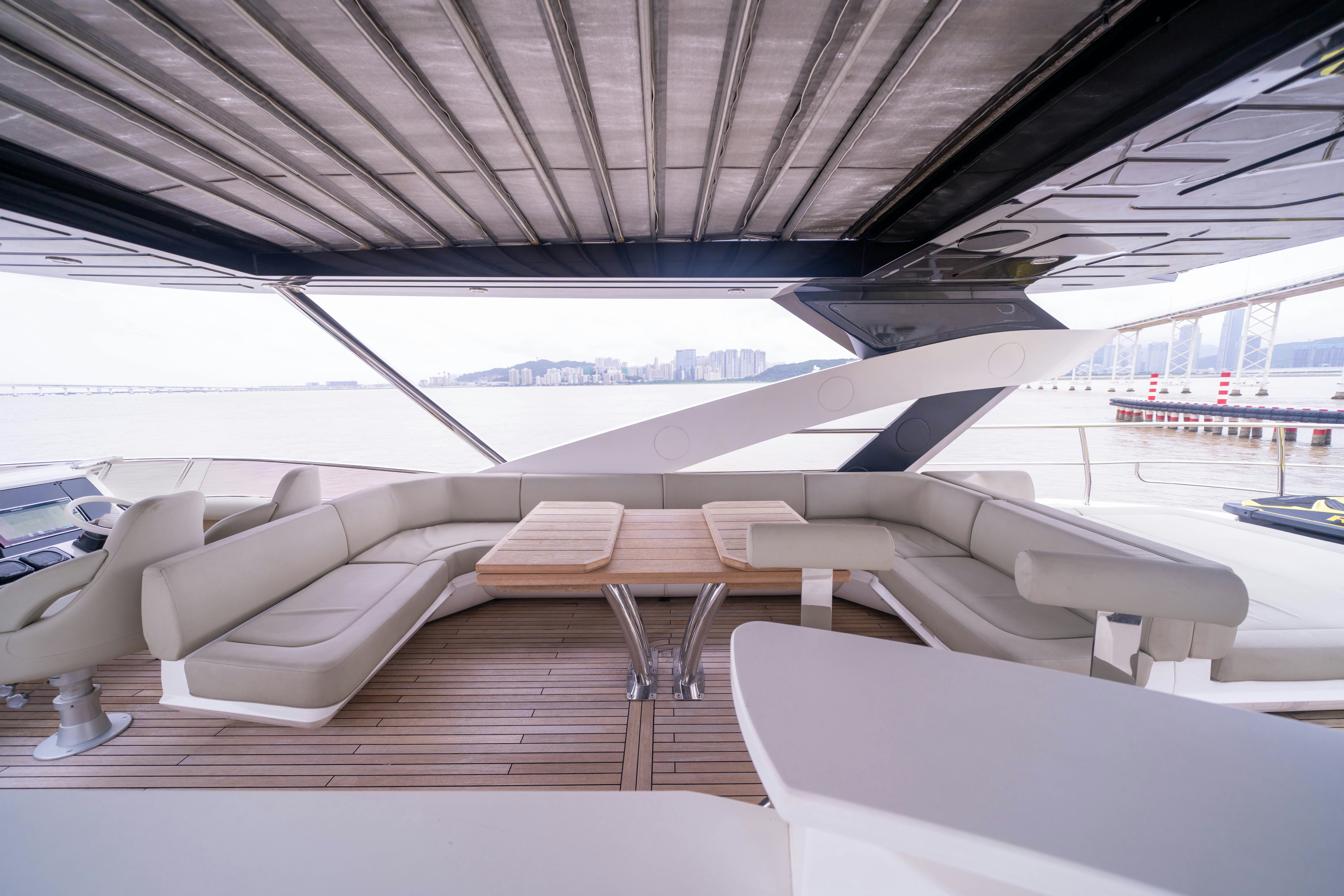 a room with a row of seats and a table with chairs aboard DRAGON Yacht for Sale