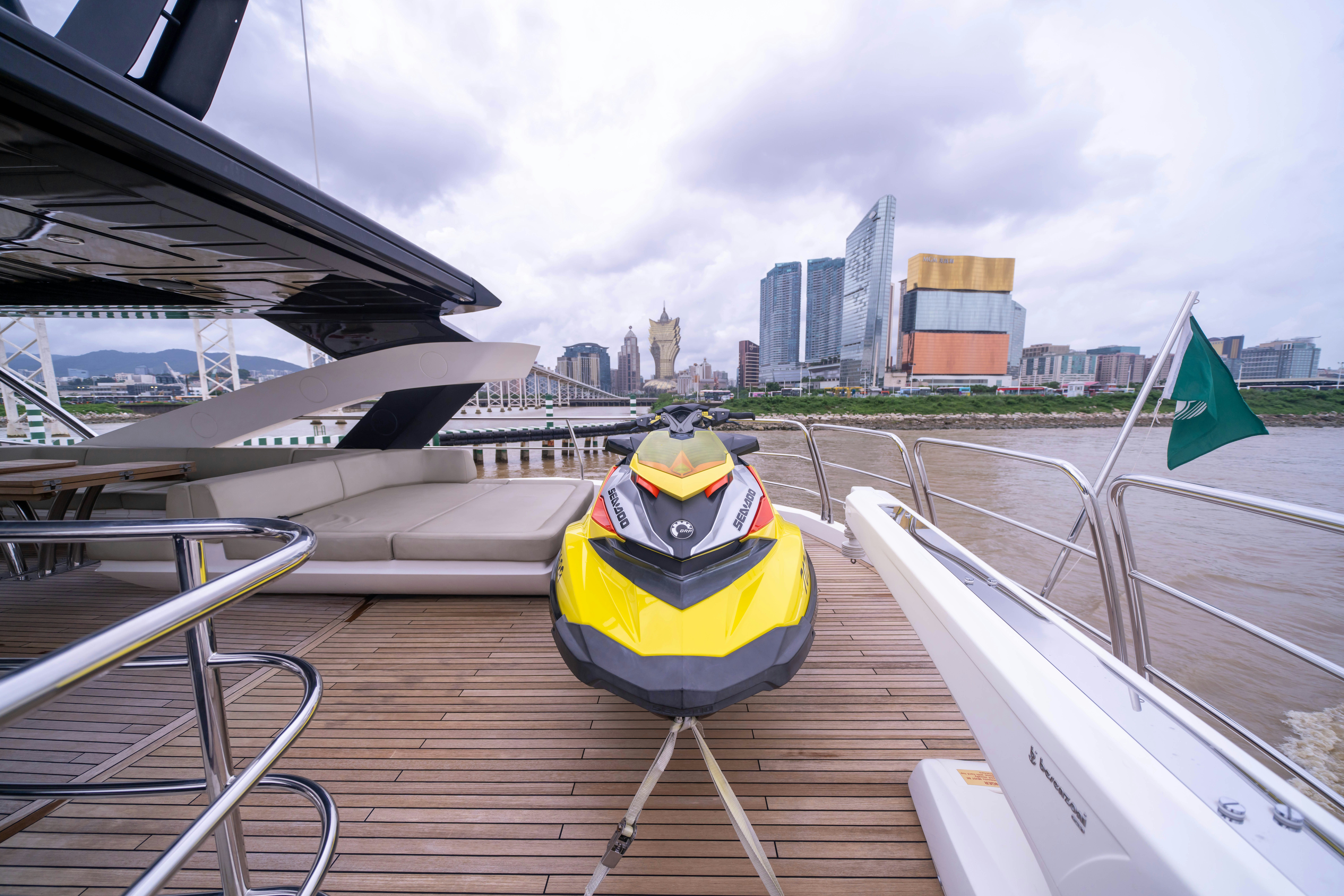 a yellow and black boat on a dock with a city in the background aboard DRAGON Yacht for Sale