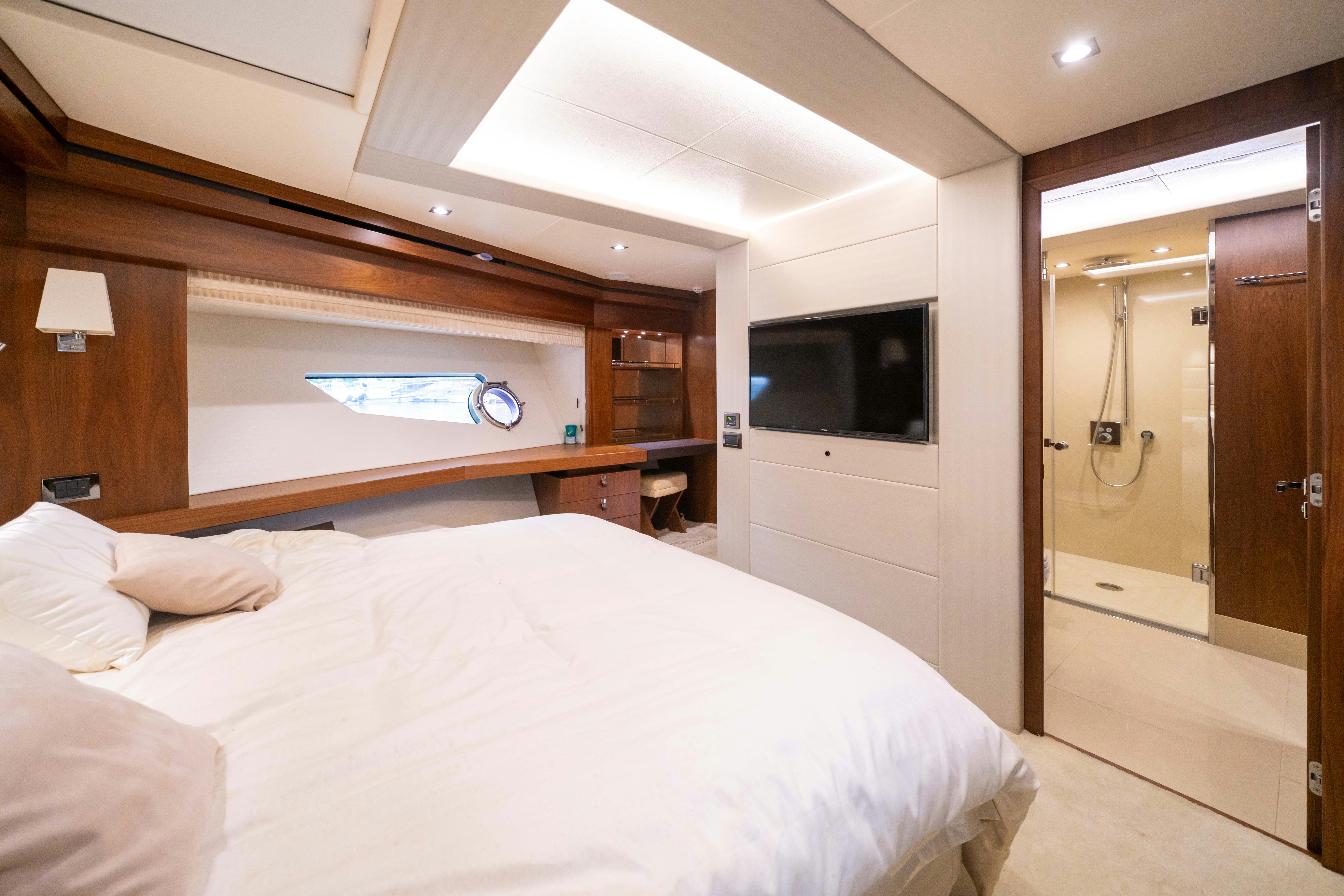 a bedroom with a bed and a television aboard DRAGON Yacht for Sale