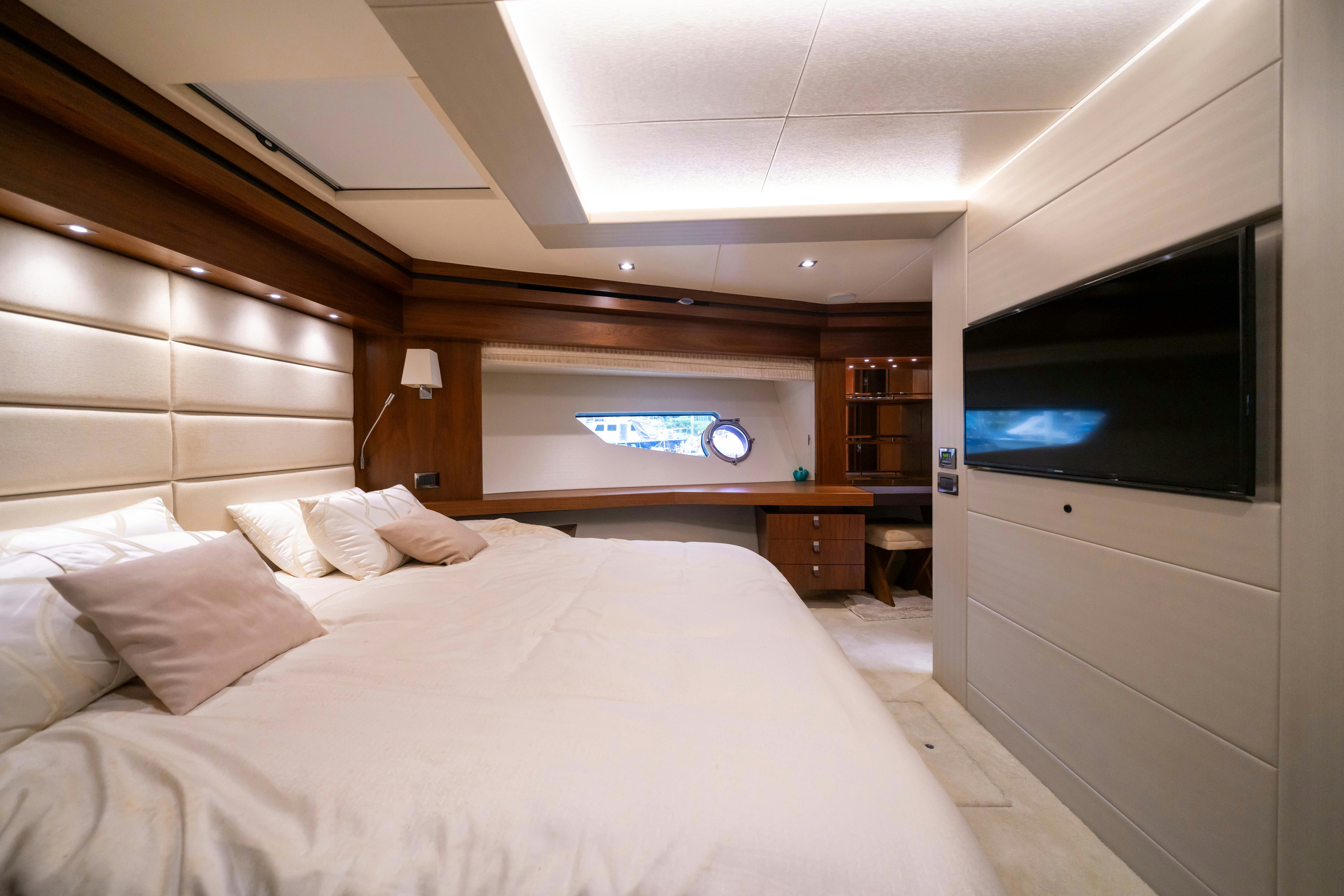 a room with a bed and a television aboard DRAGON Yacht for Sale