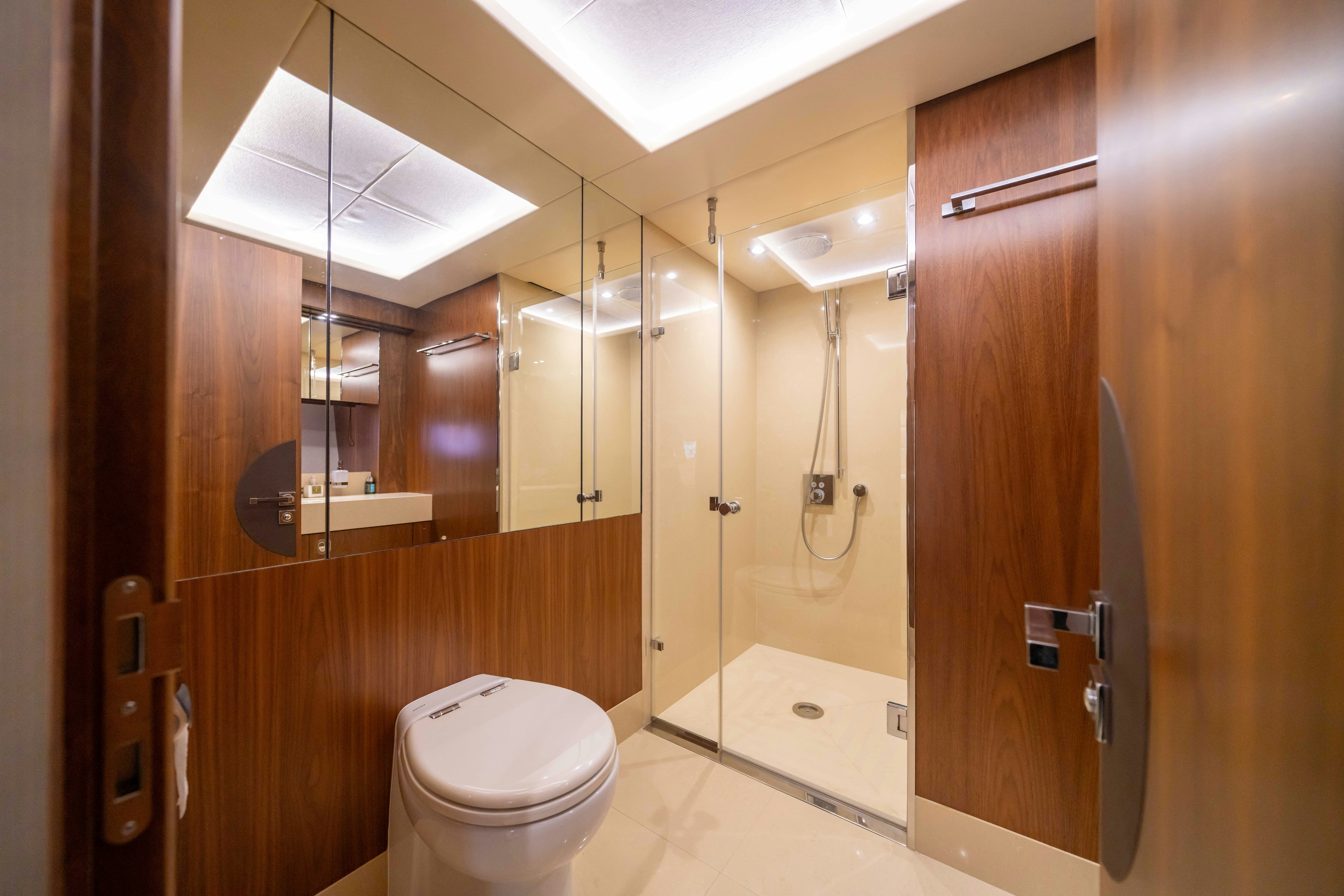 a bathroom with a toilet and a shower unit aboard DRAGON Yacht for Sale