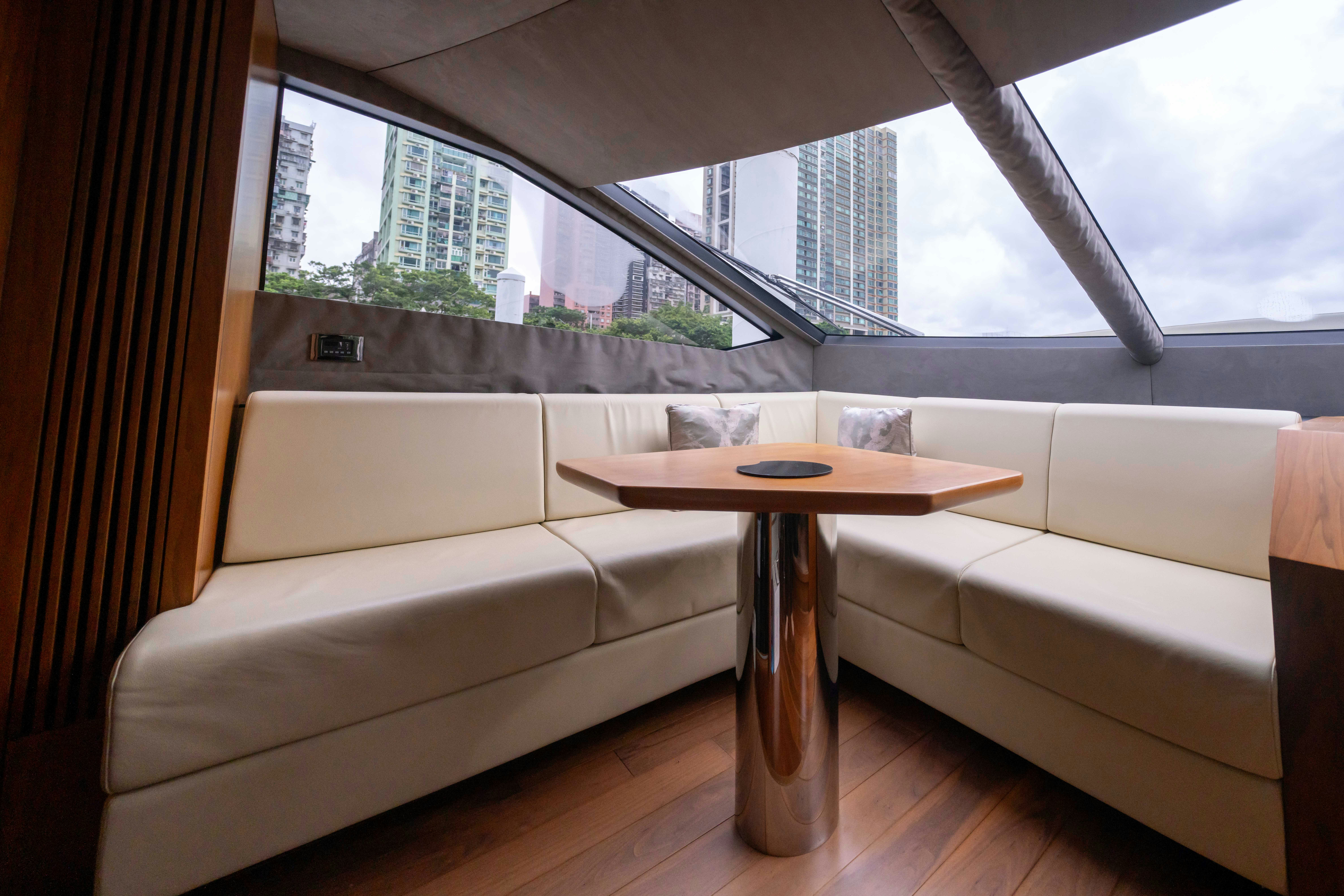 a couch and coffee table in a room with a window aboard DRAGON Yacht for Sale