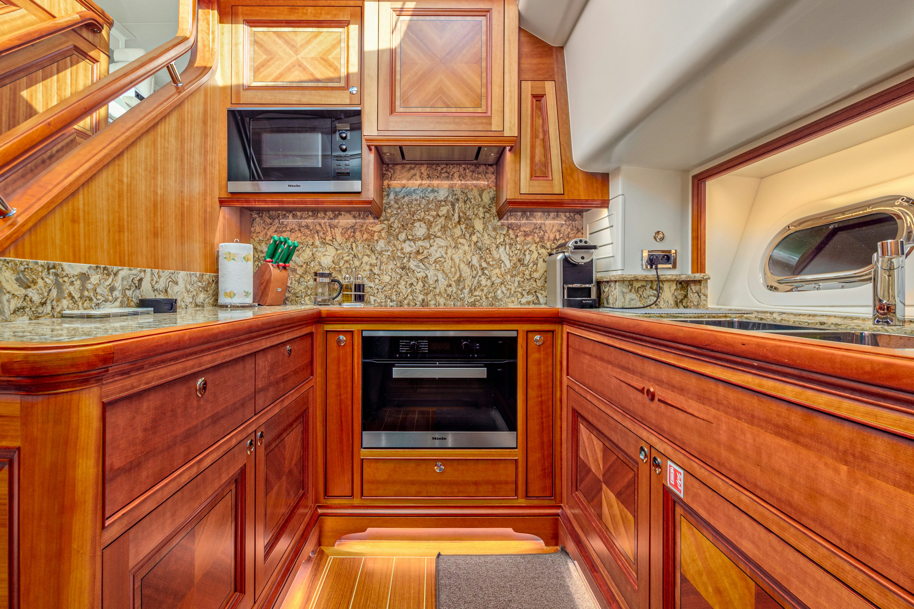 a kitchen with wooden cabinets aboard FRIVOLOUS Yacht for Sale