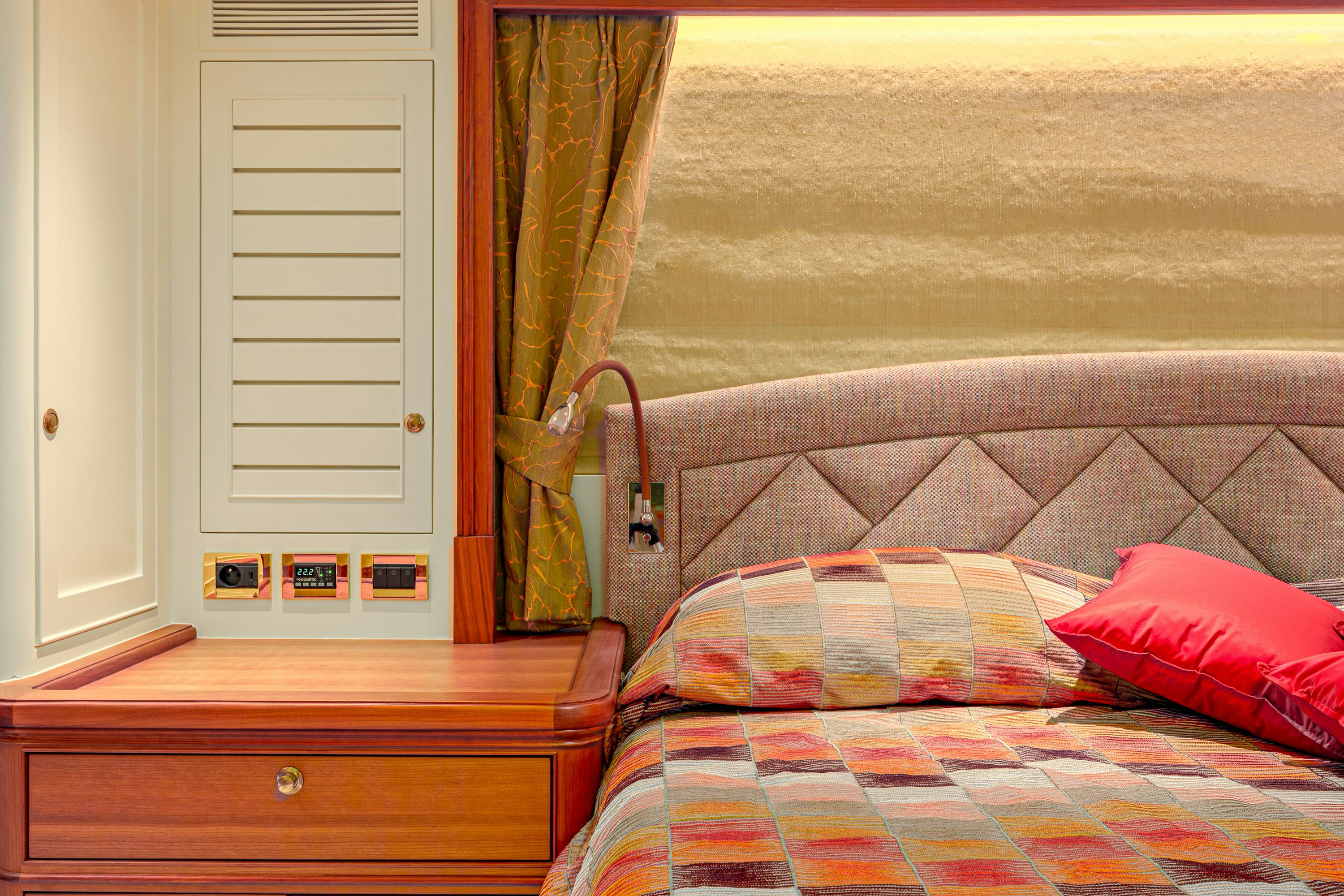 a bed with a colorful blanket aboard FRIVOLOUS Yacht for Sale