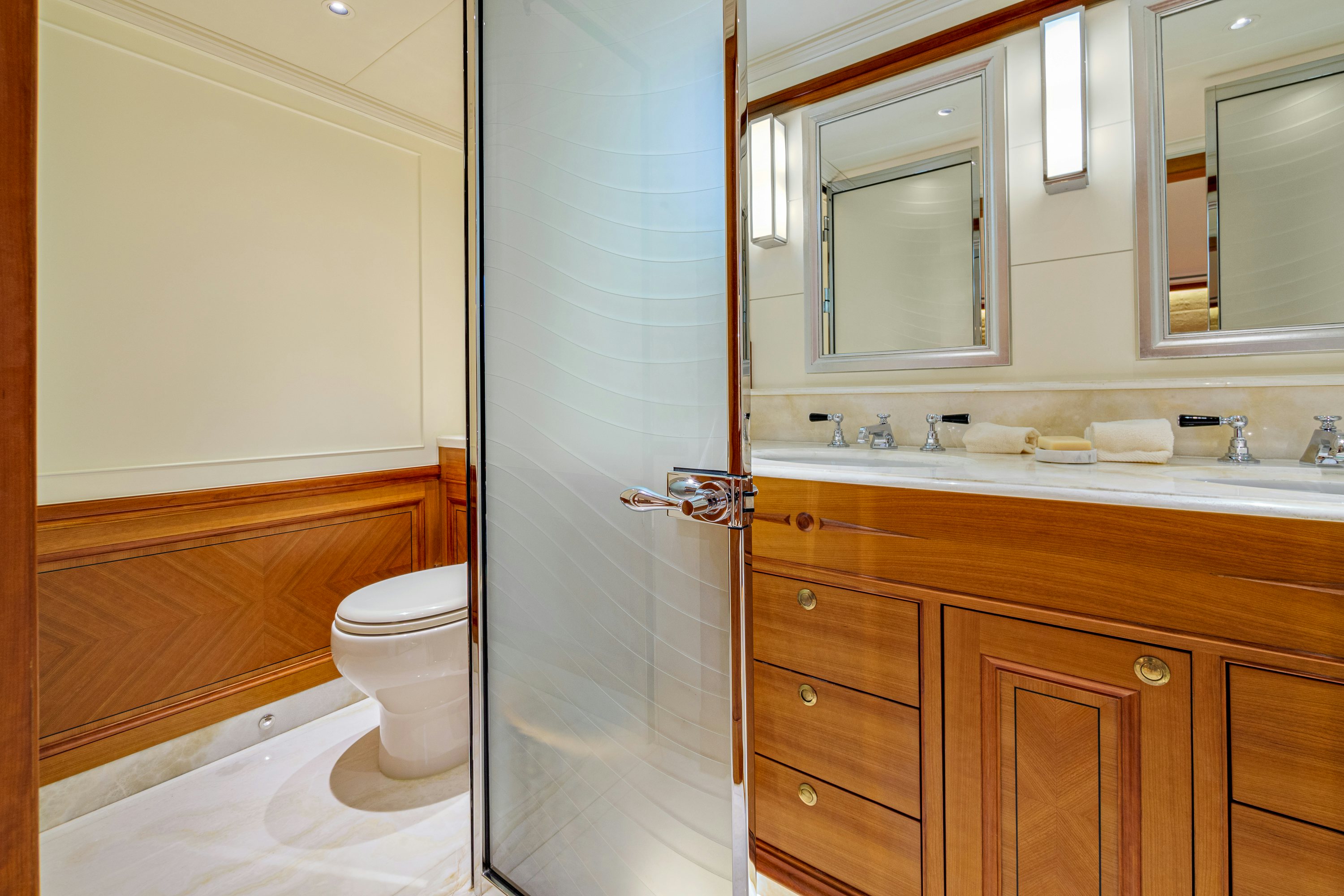 a bathroom with a toilet and a sink aboard FRIVOLOUS Yacht for Sale