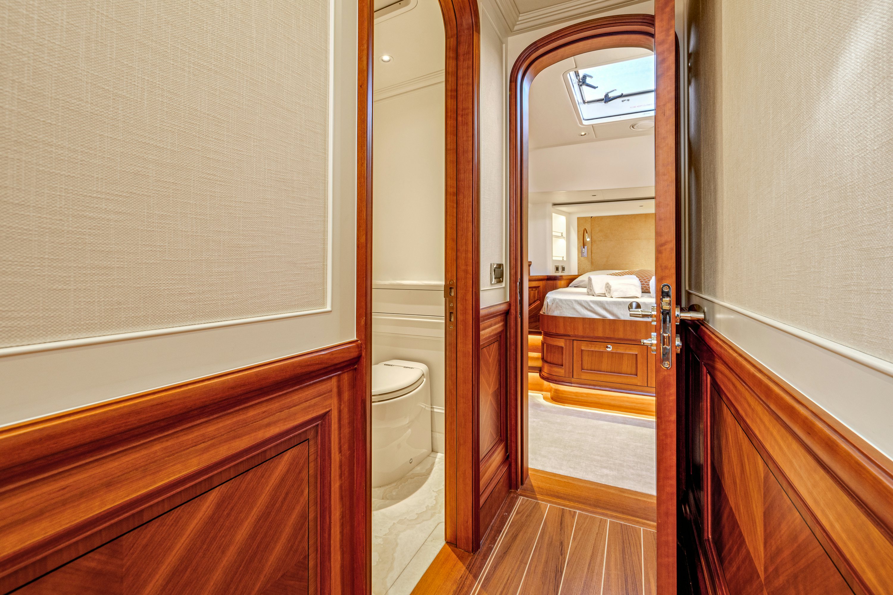 a bathroom with a toilet and a mirror aboard FRIVOLOUS Yacht for Sale
