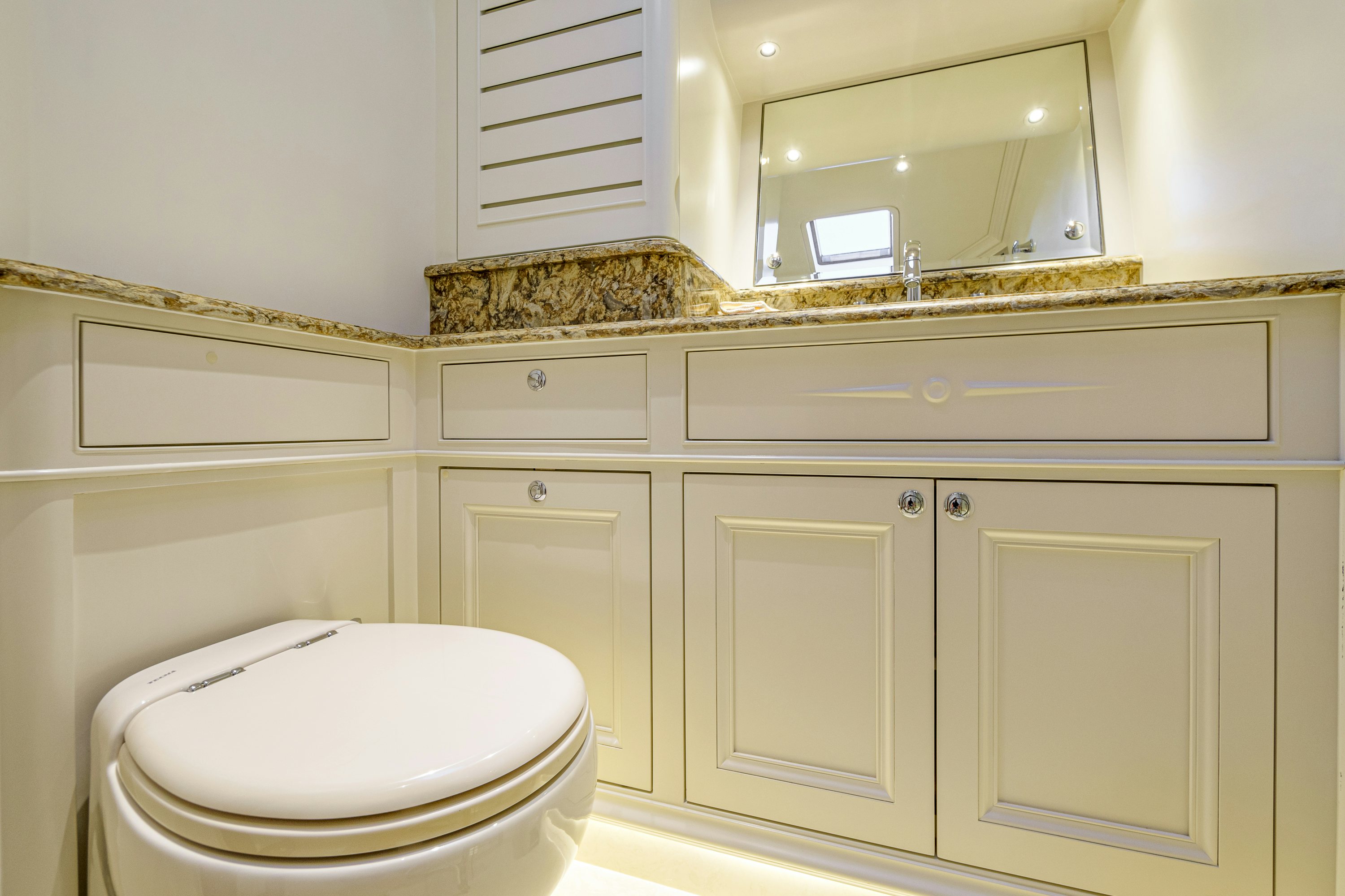 a bathroom with a toilet and a mirror aboard FRIVOLOUS Yacht for Sale