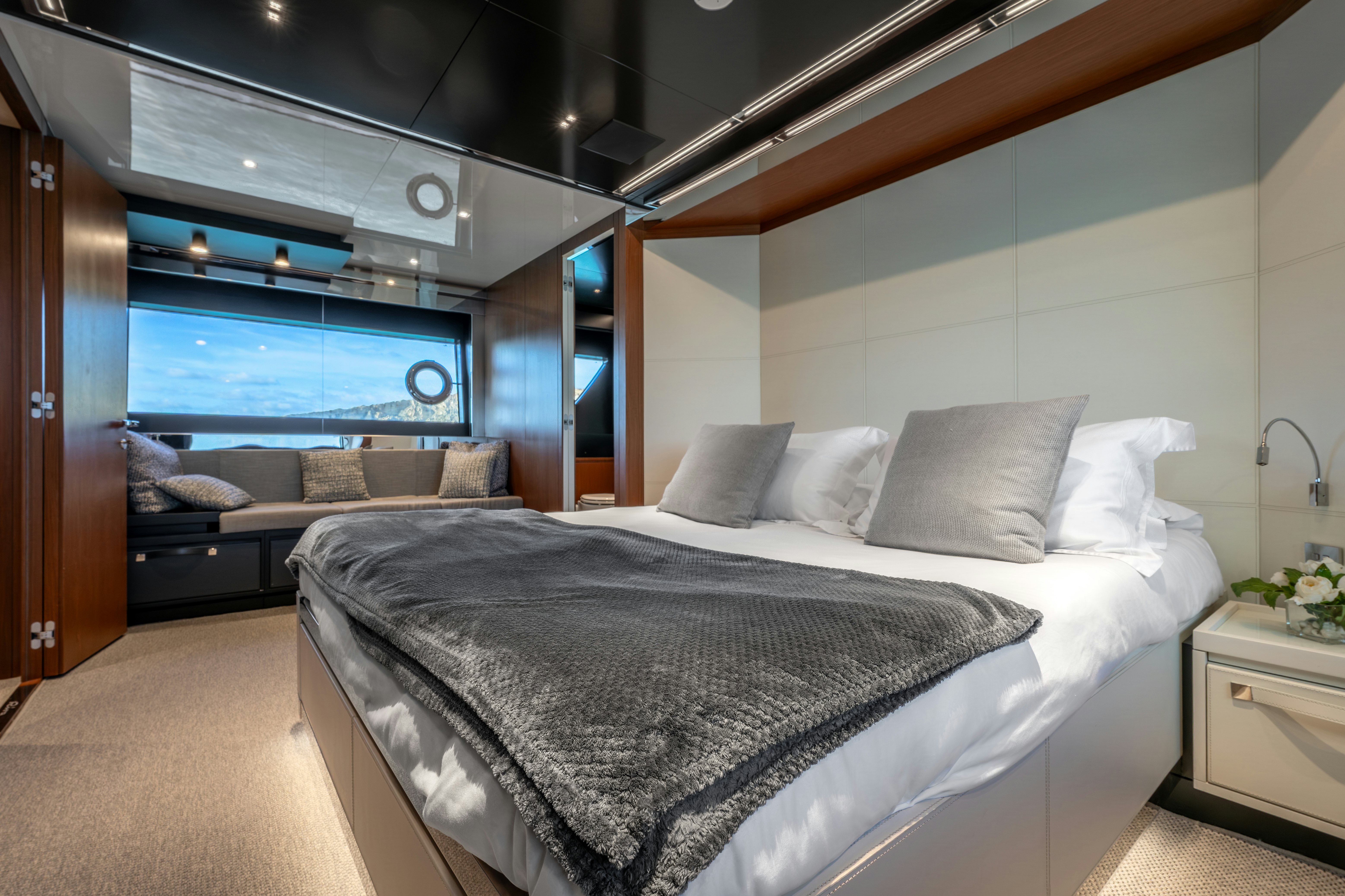 a room with a bed and a large window aboard NOI Yacht for Sale