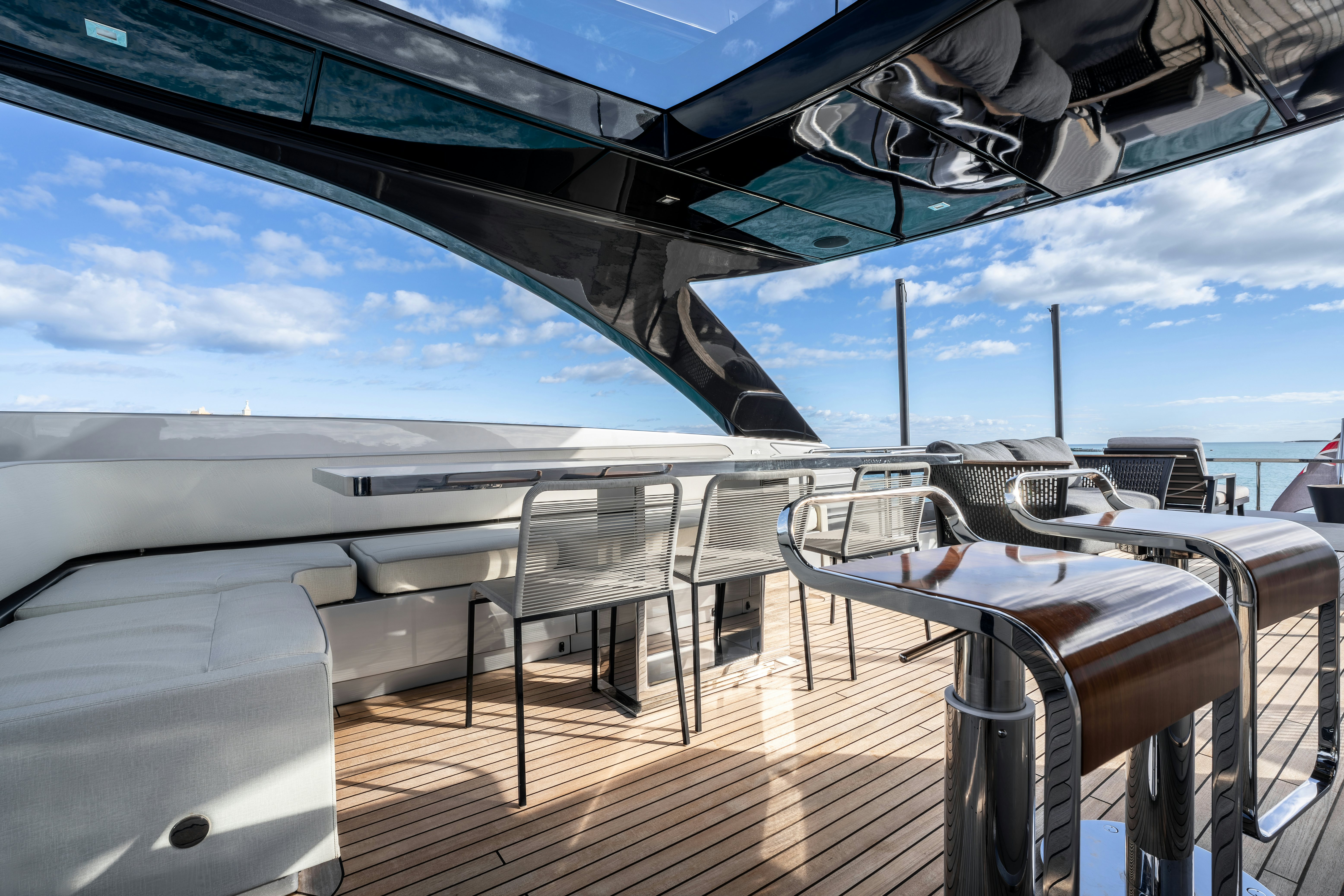 a deck with chairs and tables on it aboard NOI Yacht for Sale