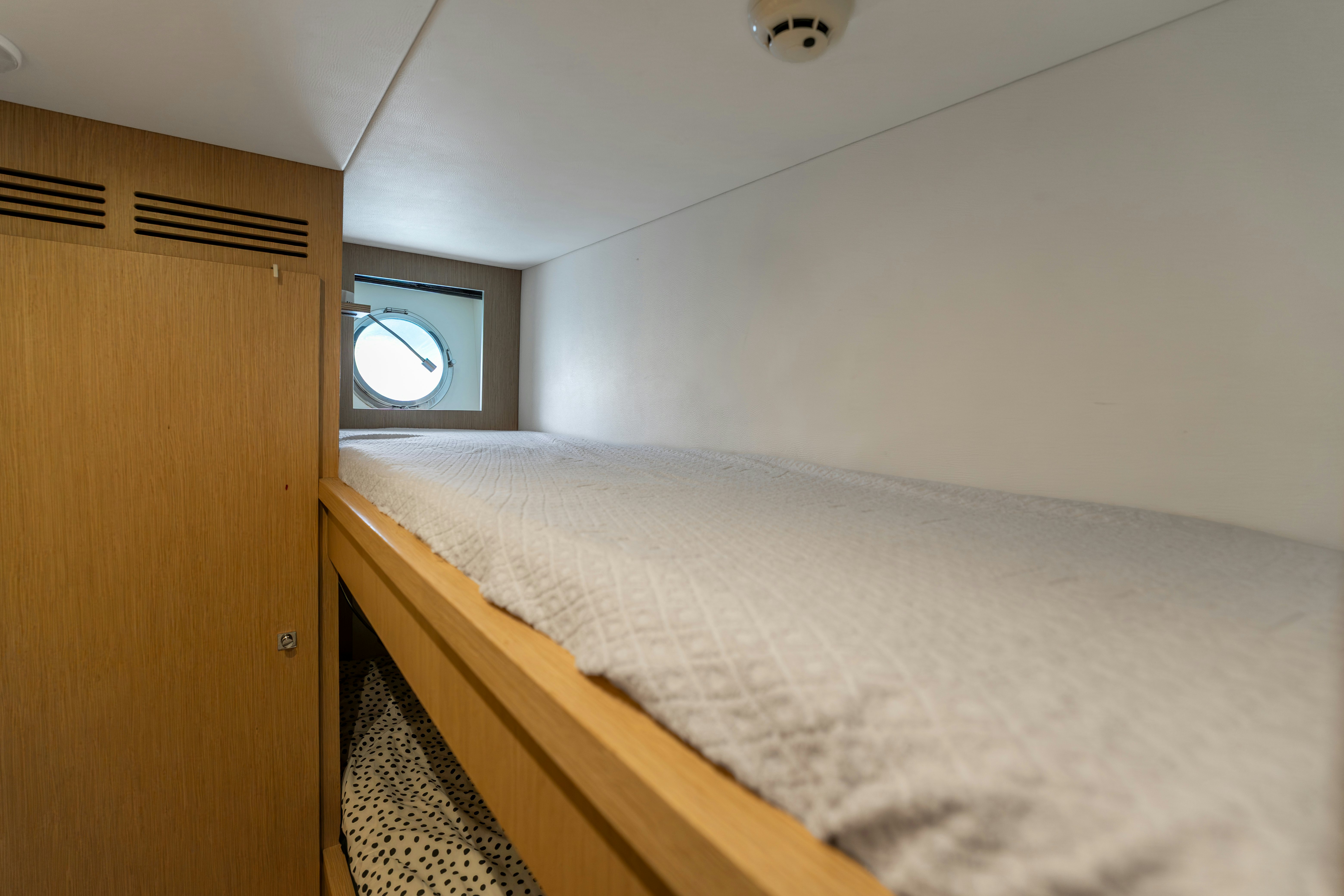 a bed with a wooden headboard aboard NOI Yacht for Sale