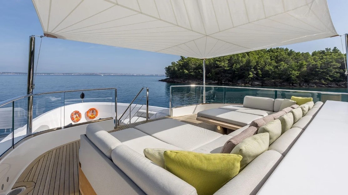 a lounge chair on a deck overlooking a body of water aboard ANDIAMO Yacht for Charter