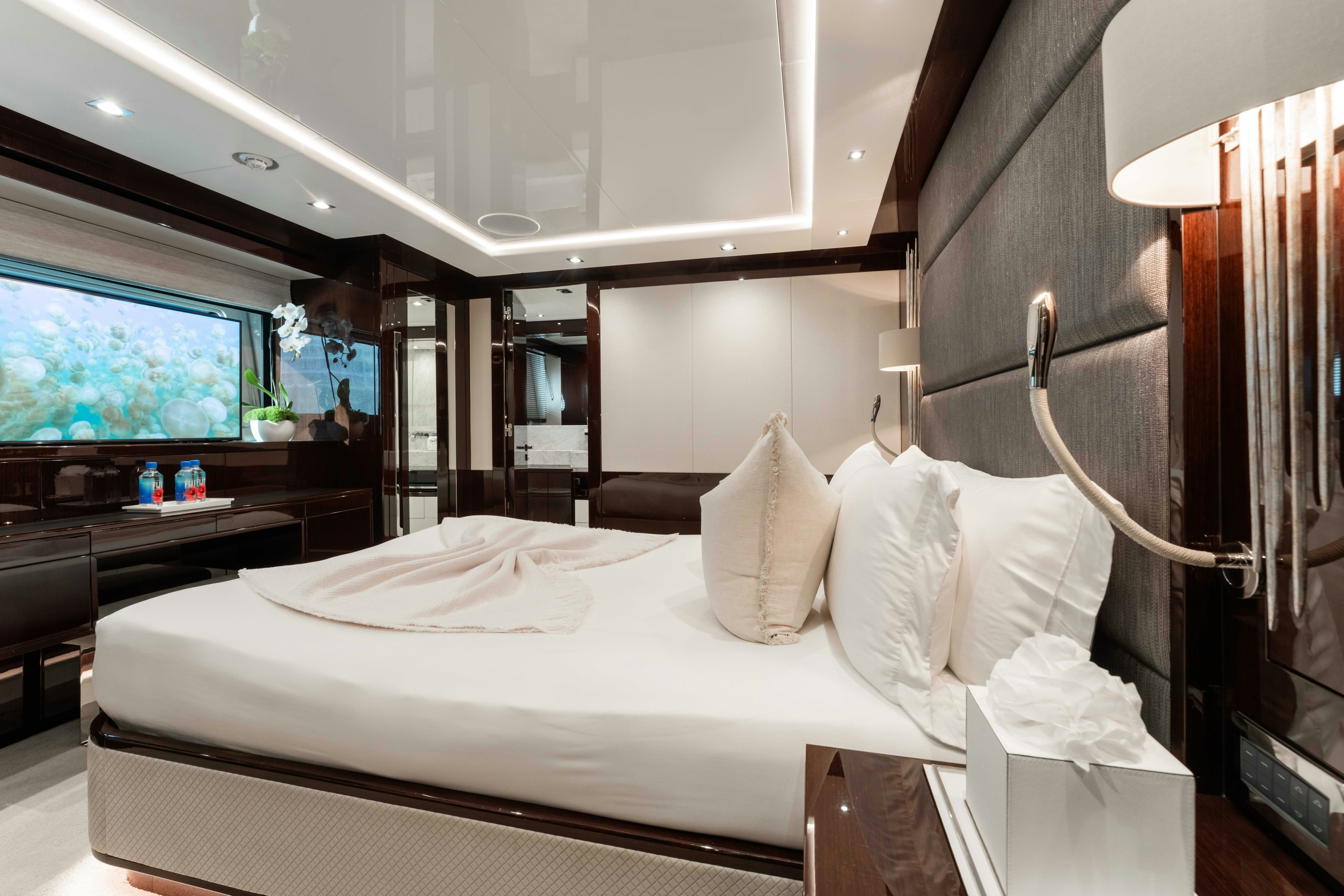 a hotel room with a bed and a television aboard CAPTAIN MORGAN III Yacht for Charter