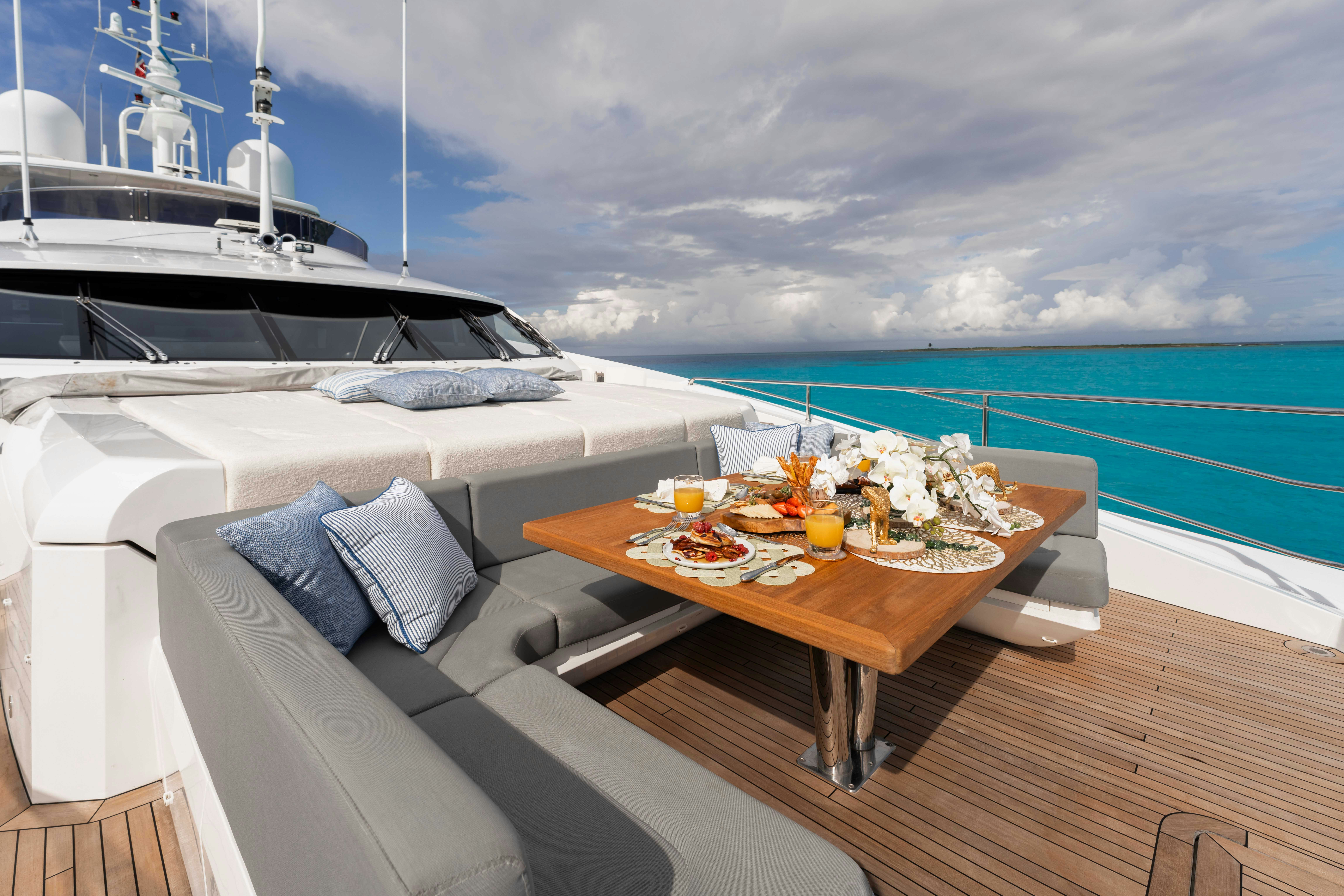 a table with food on it next to a boat on a body of water aboard CAPTAIN MORGAN III Yacht for Charter