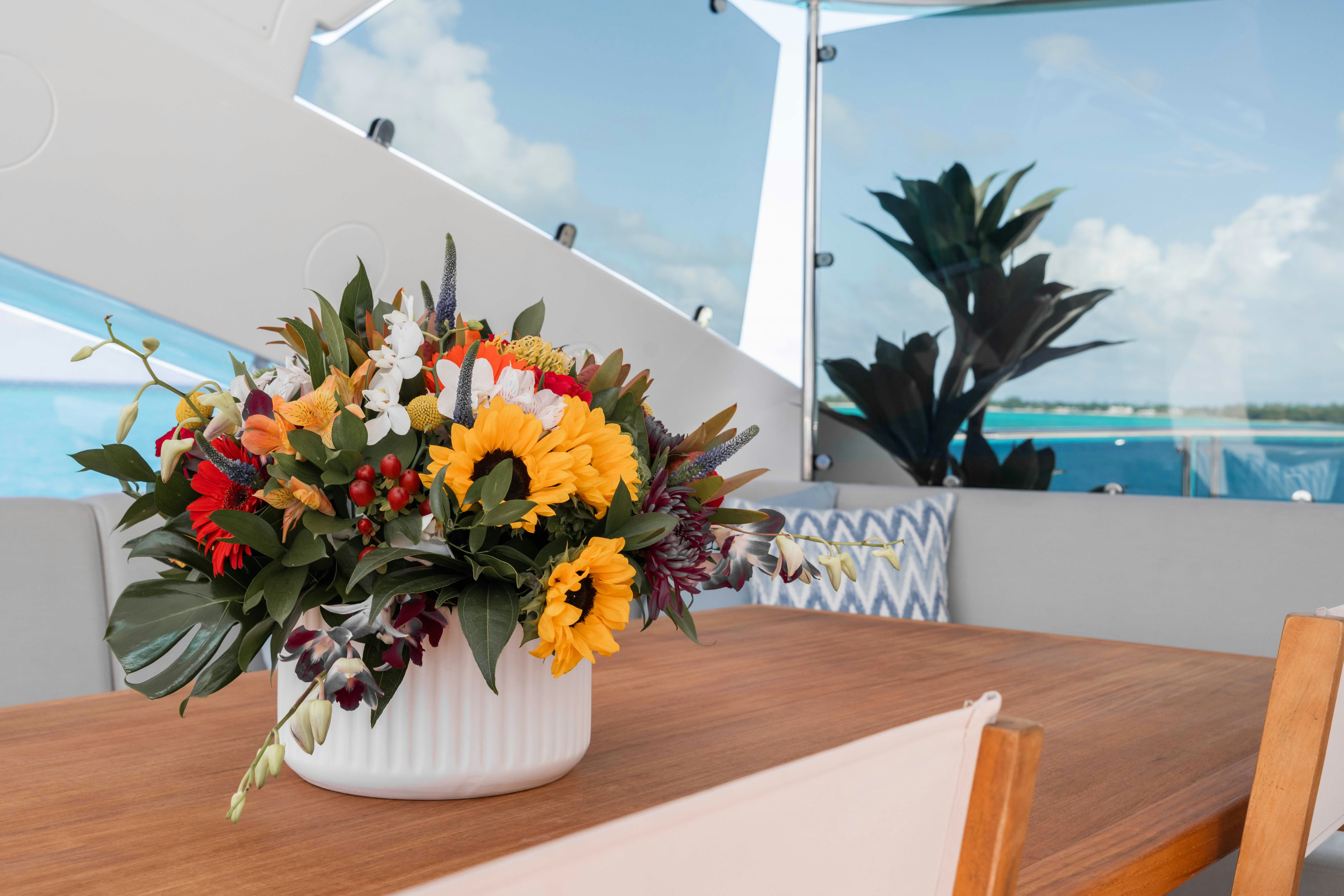 a vase of yellow and red flowers on a table aboard CAPTAIN MORGAN III Yacht for Charter