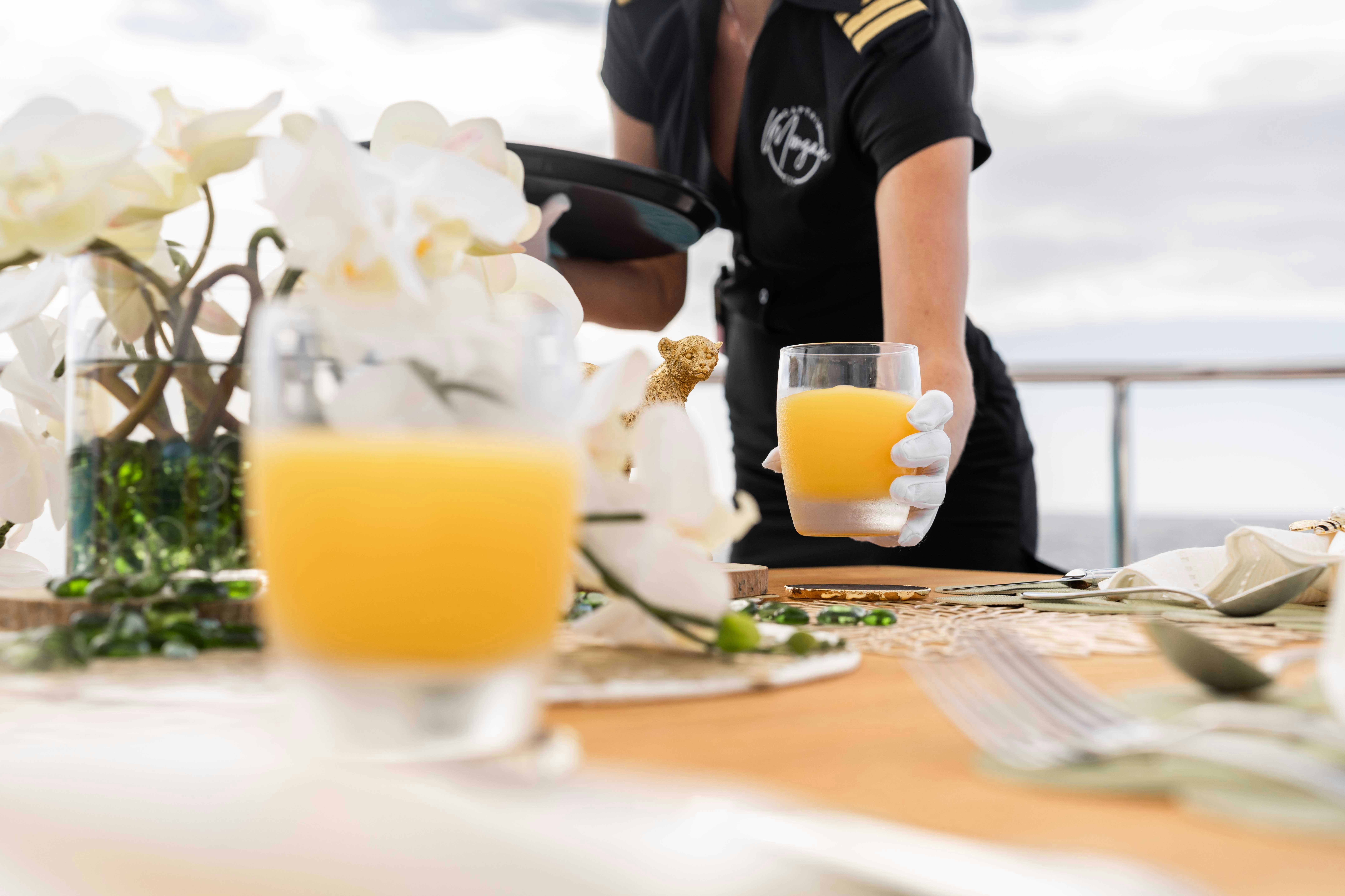a table with glasses of liquid and a plate of food aboard CAPTAIN MORGAN III Yacht for Charter