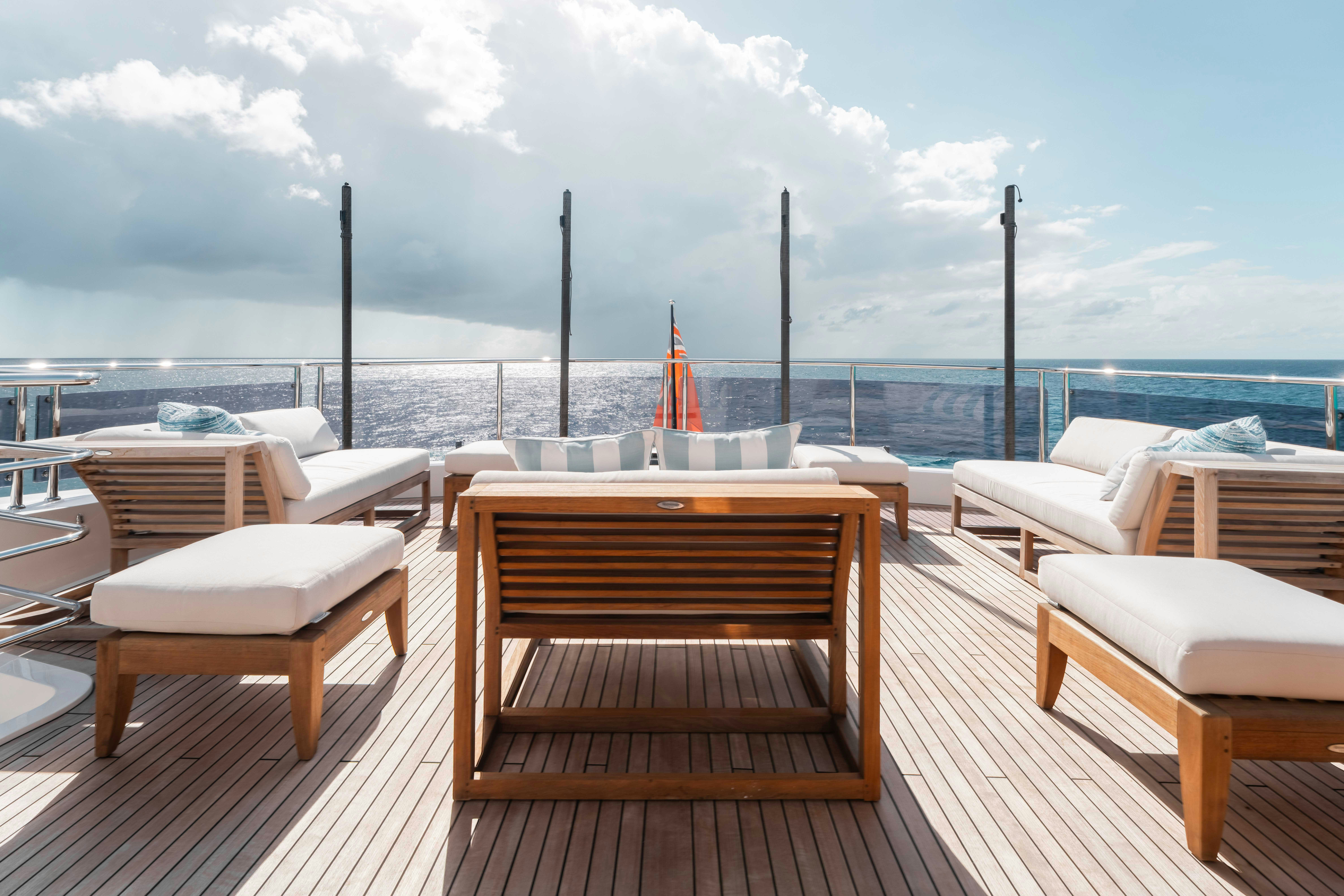 a deck with chairs and tables on it by the water aboard CAPTAIN MORGAN III Yacht for Charter