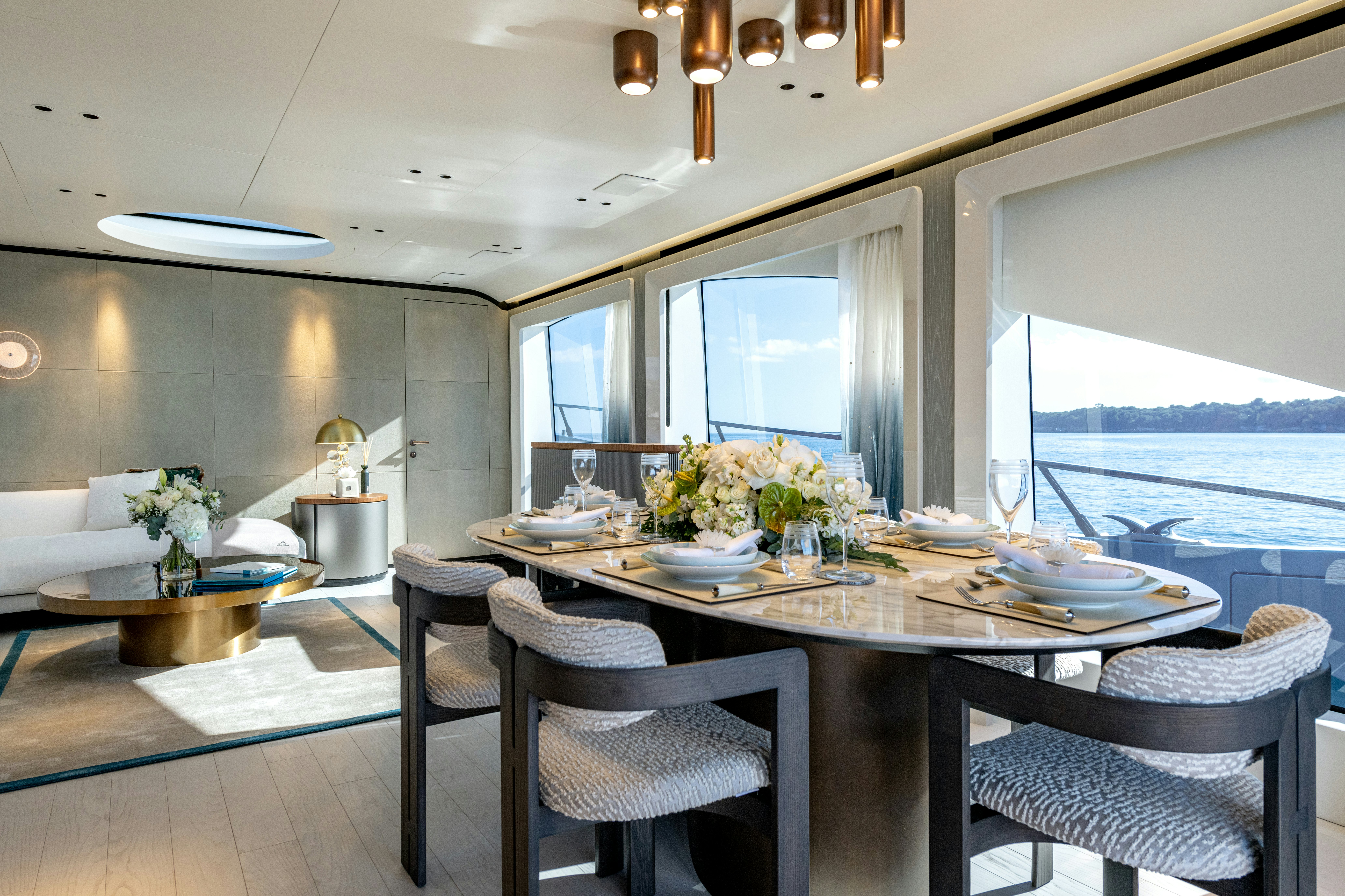 a dining table with a view of the ocean aboard DELFINA Yacht for Sale