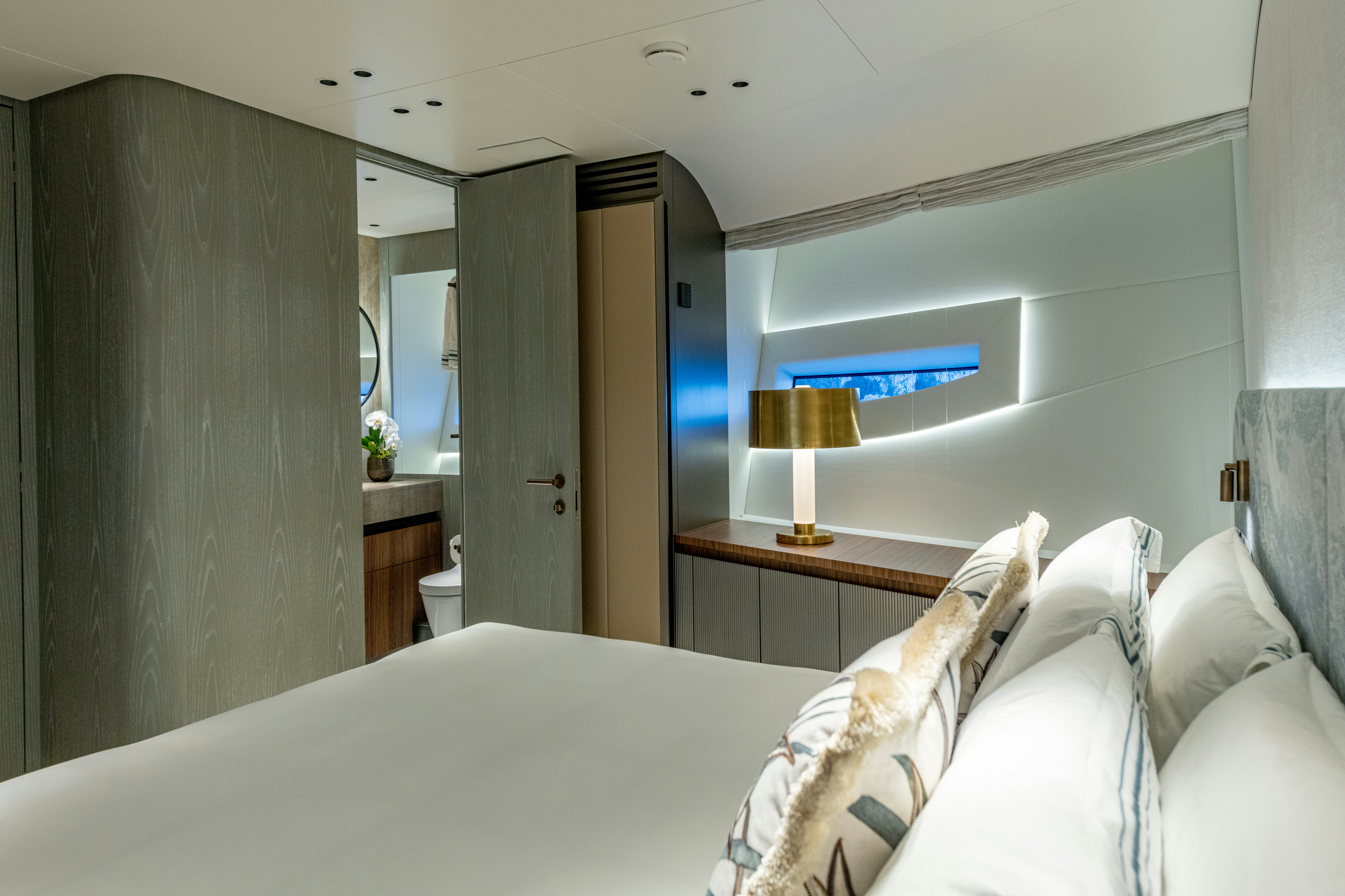 a bedroom with a bed and a lamp aboard DELFINA Yacht for Sale
