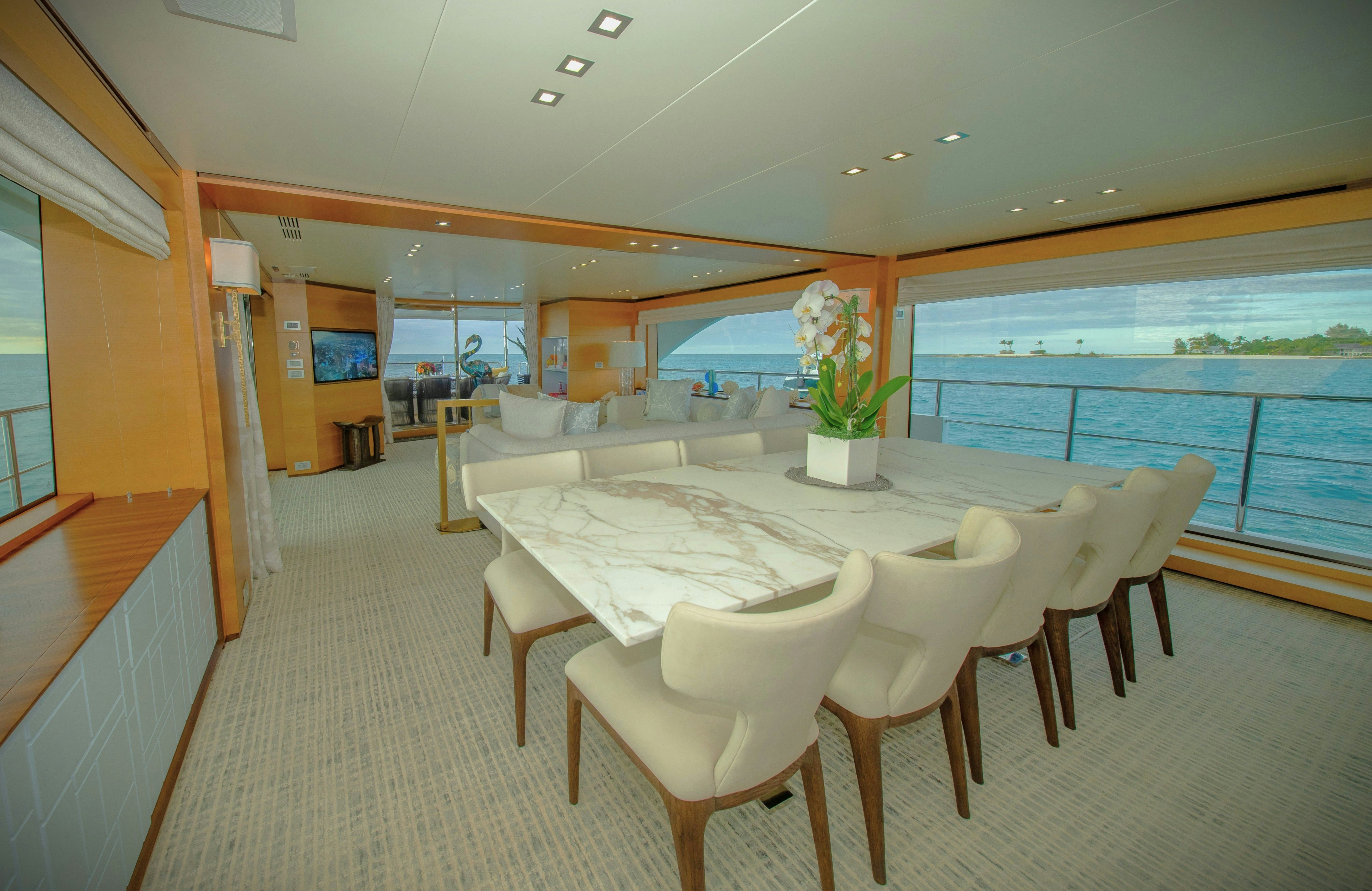 a room with tables and chairs aboard REHAB Yacht for Sale