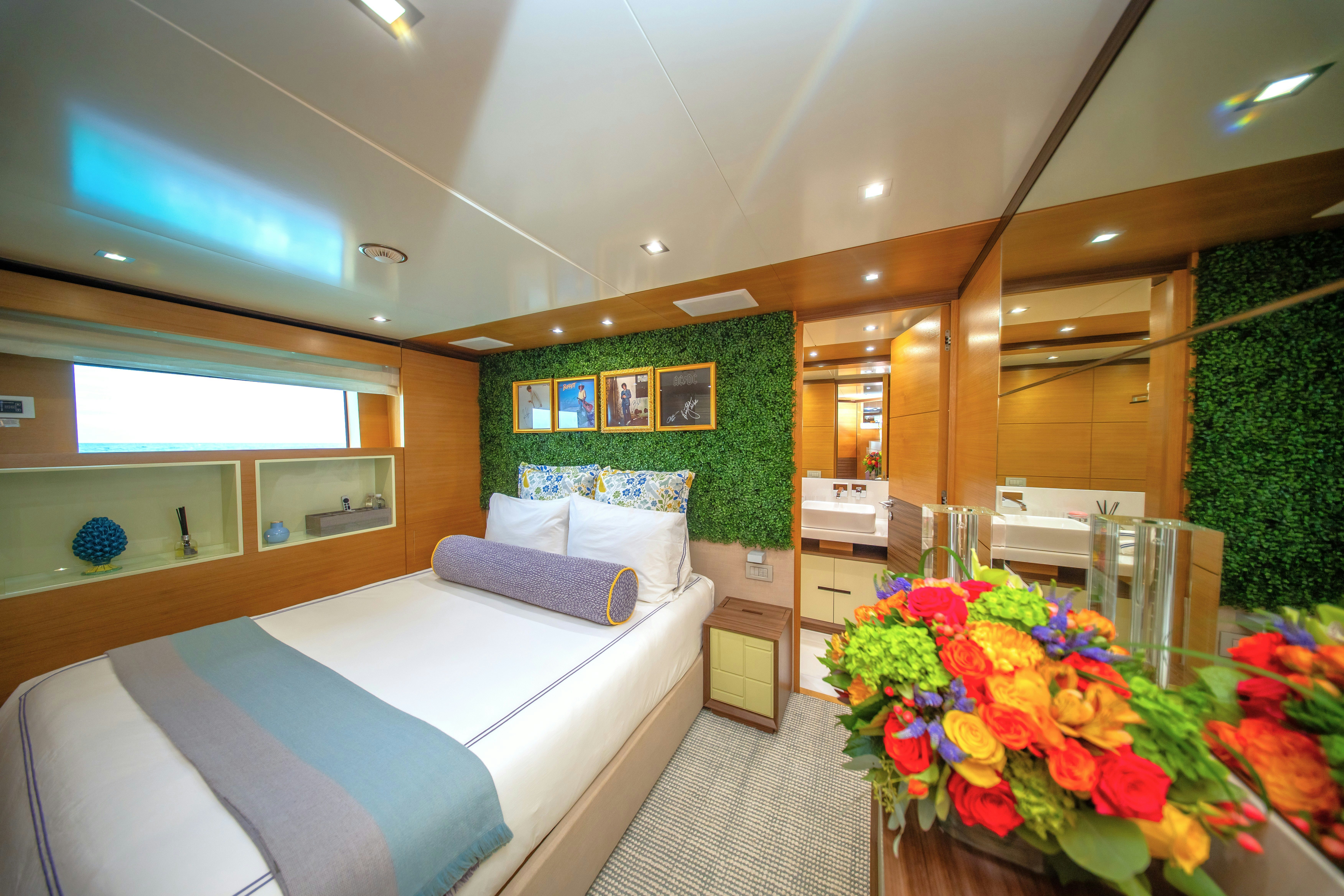 a room with a bed and a table with flowers aboard REHAB Yacht for Sale
