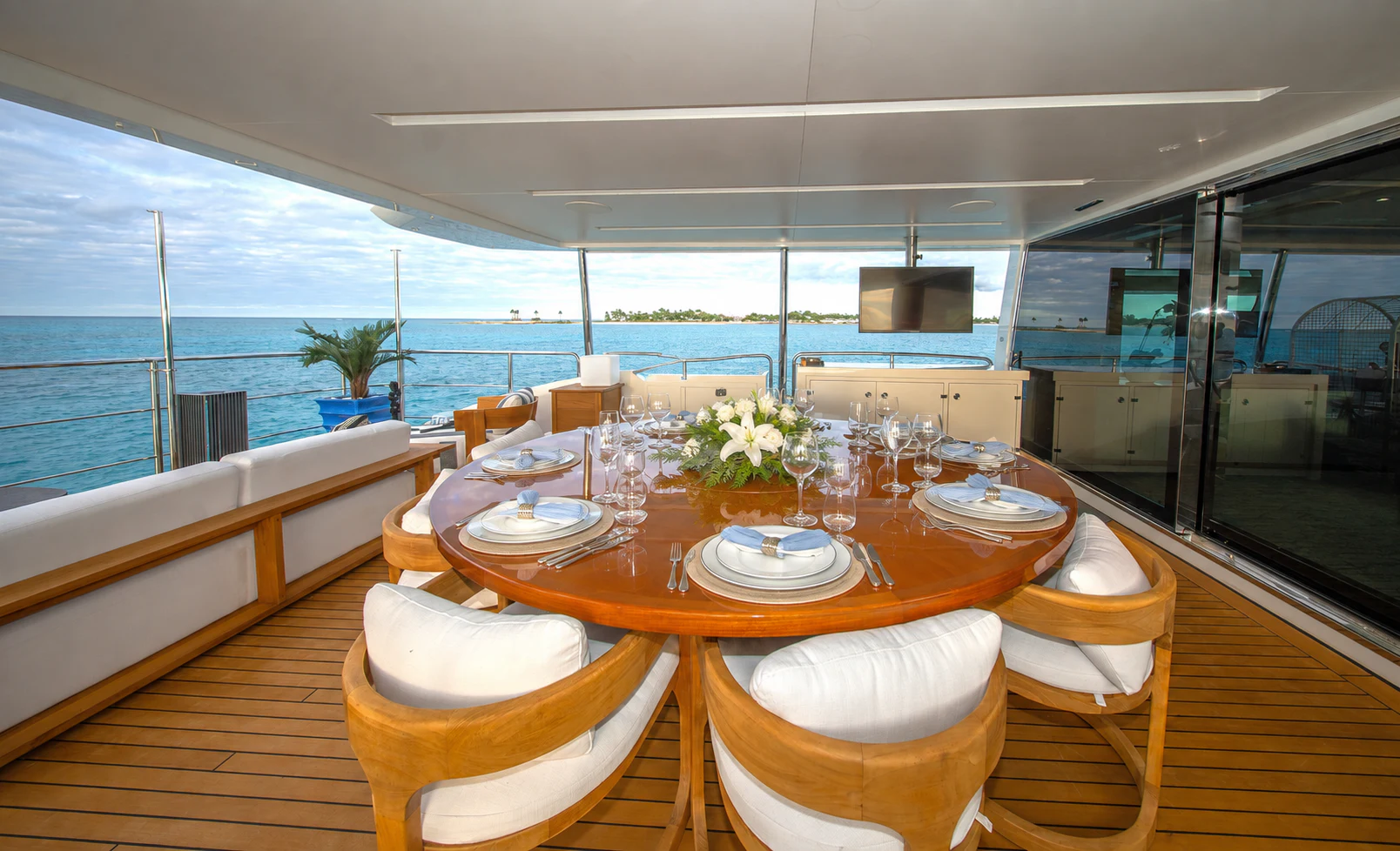 a table with chairs and a view of the ocean aboard REHAB Yacht for Sale