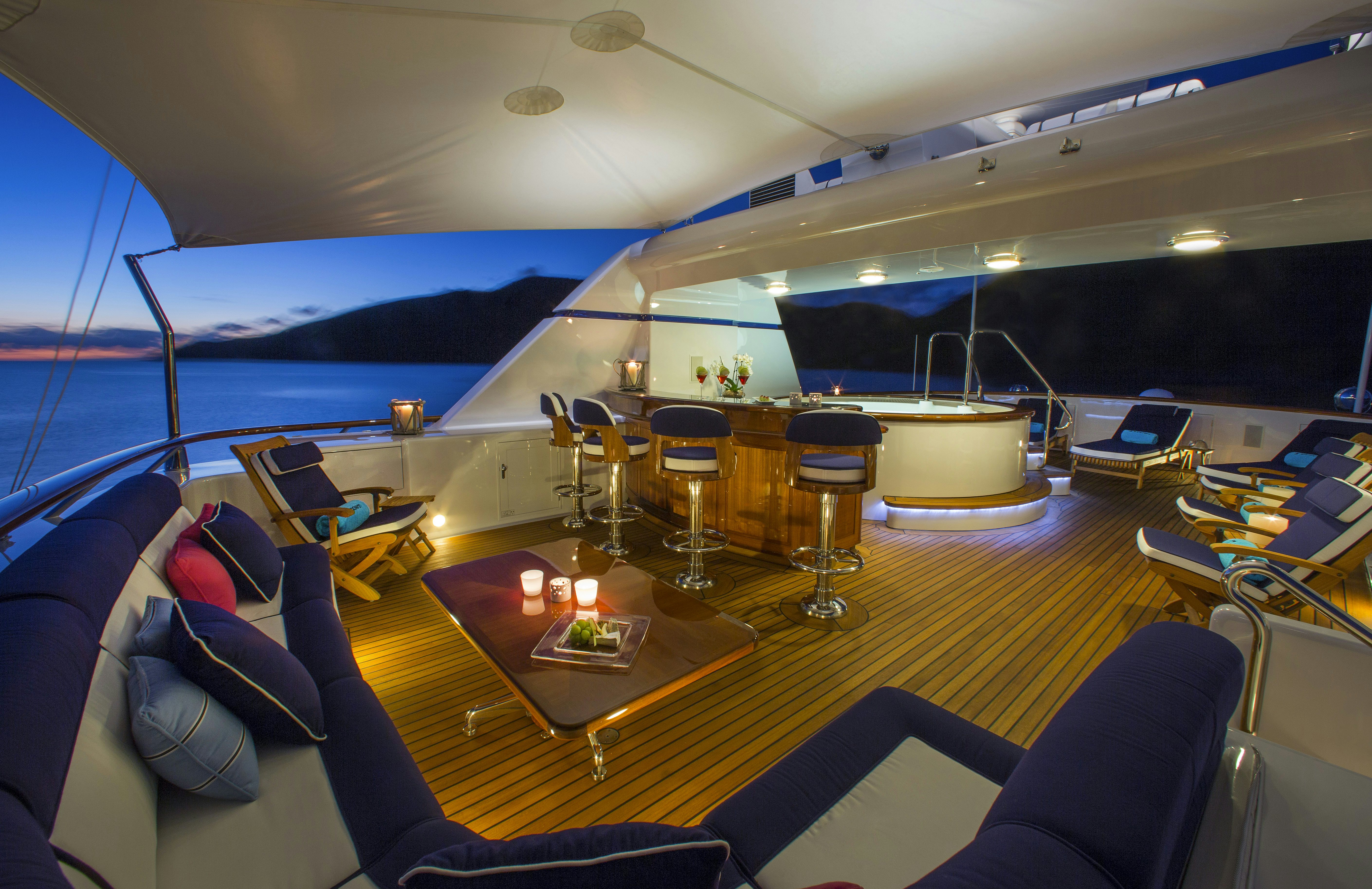 a large ship with a table and chairs and a table with a view of the ocean aboard TELEOST Yacht for Charter