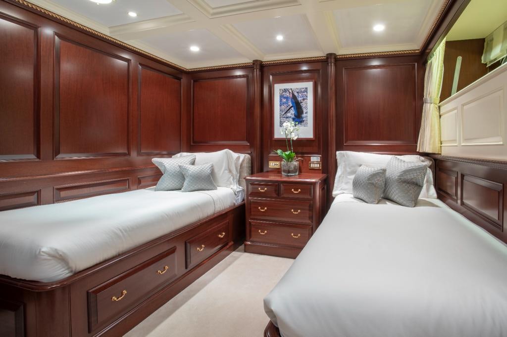 a room with a bed and a dresser aboard TELEOST Yacht for Charter