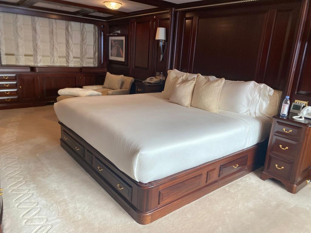 a bed with a white sheet aboard TELEOST Yacht for Charter