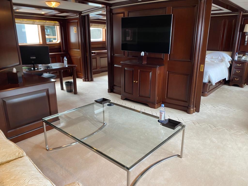 a living room with a tv and a table aboard TELEOST Yacht for Charter