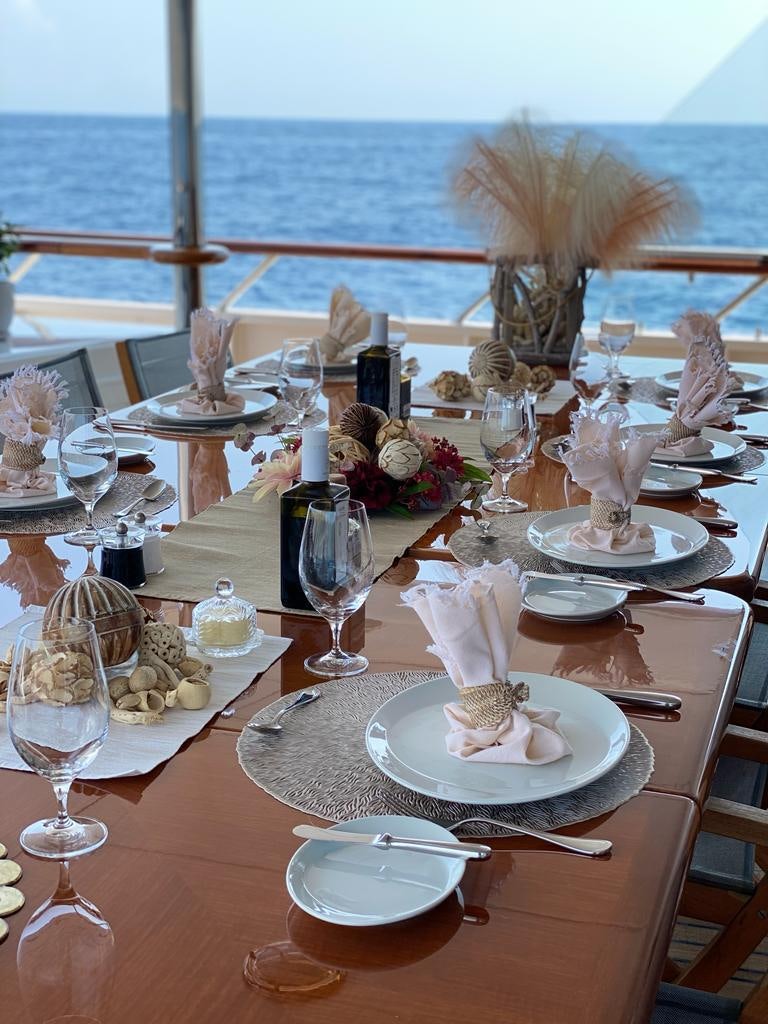a table with plates and glasses aboard TELEOST Yacht for Charter