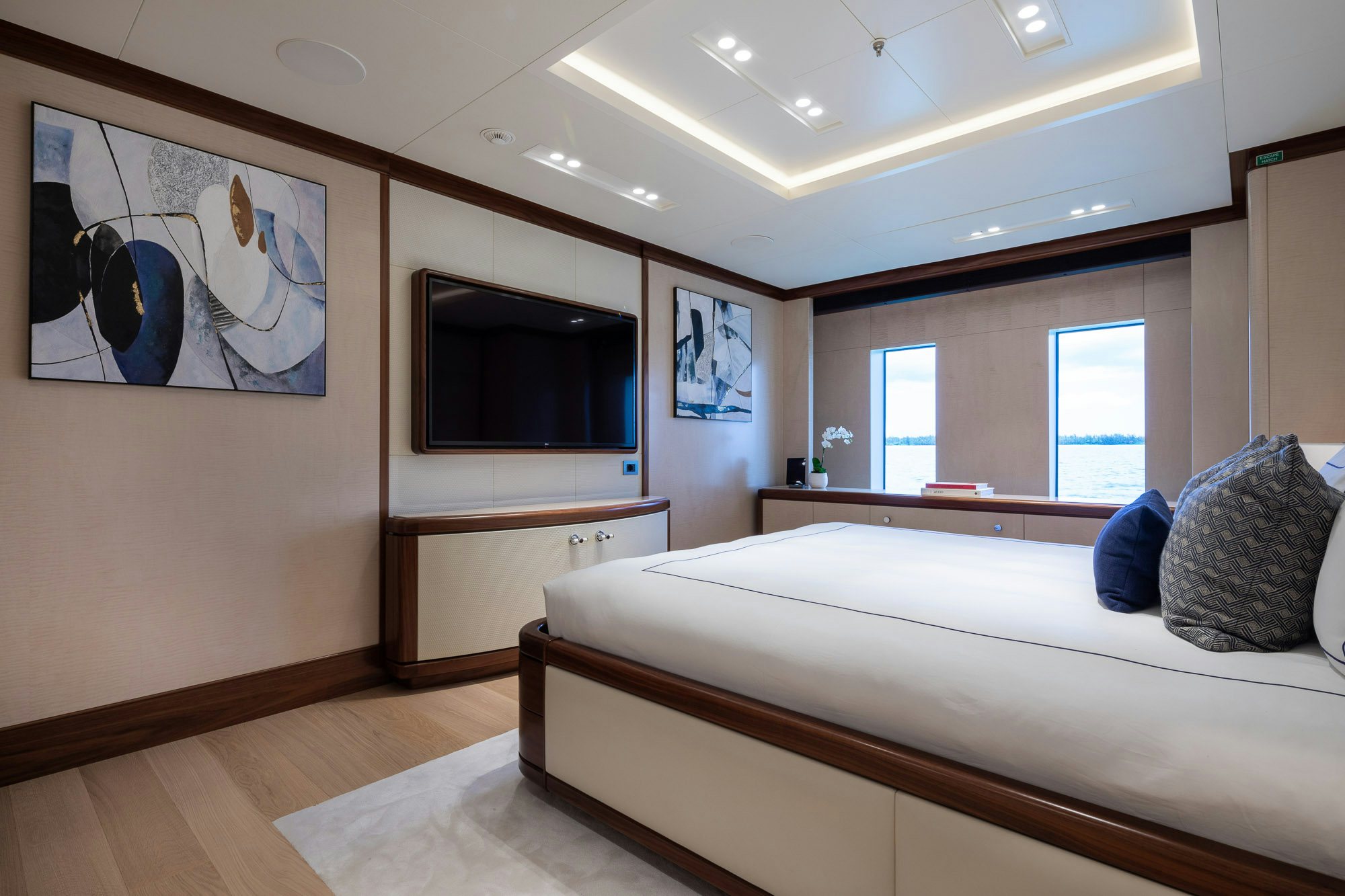 a bedroom with a bed and a tv on the wall aboard CALEX Yacht for Charter