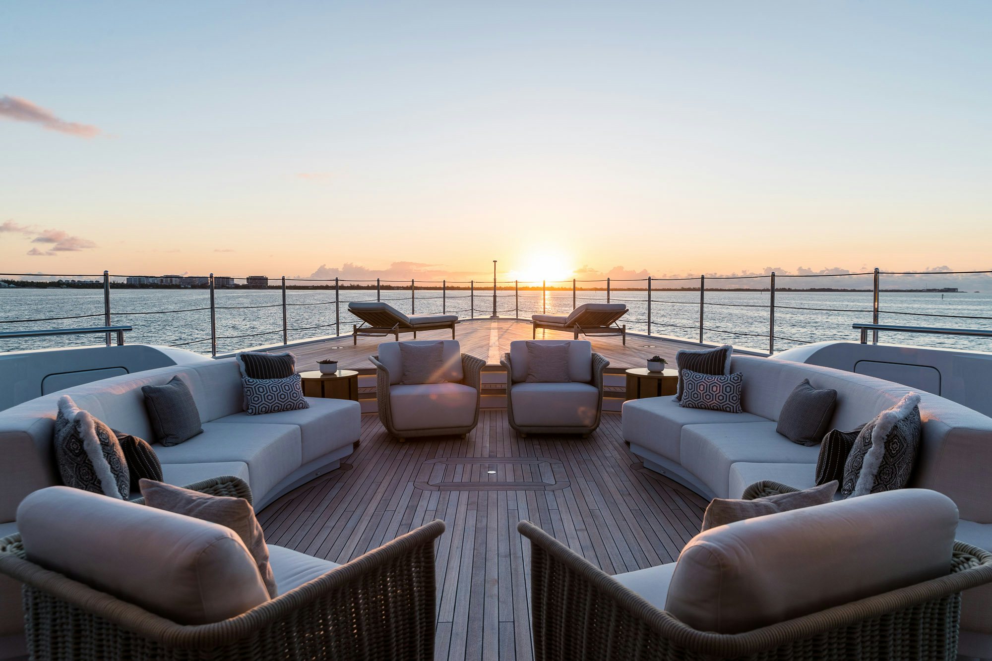 a patio with a large body of water and a large boat in the background aboard CALEX Yacht for Charter