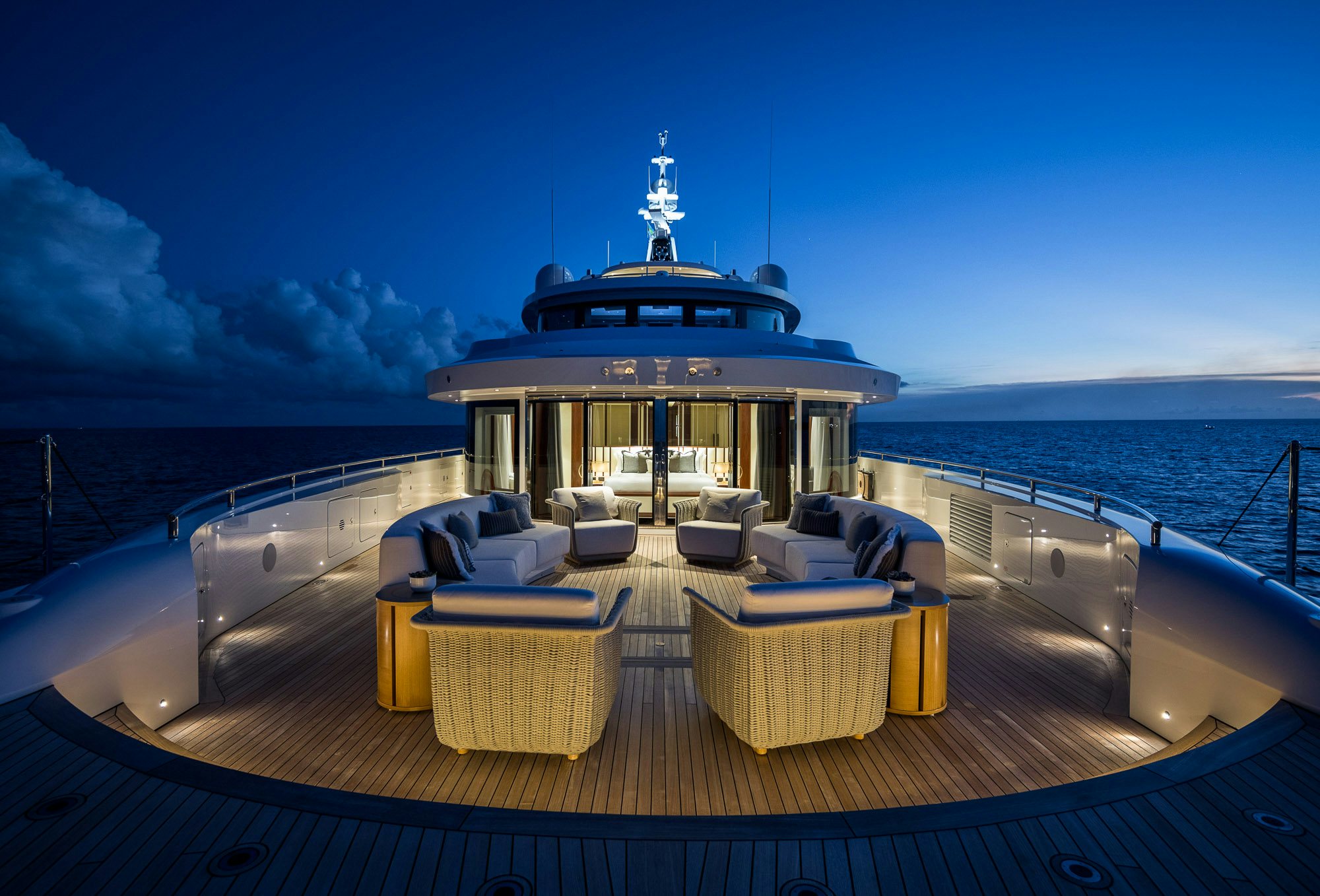 a deck with a large cruise ship on it and a large body of water in the background aboard CALEX Yacht for Charter