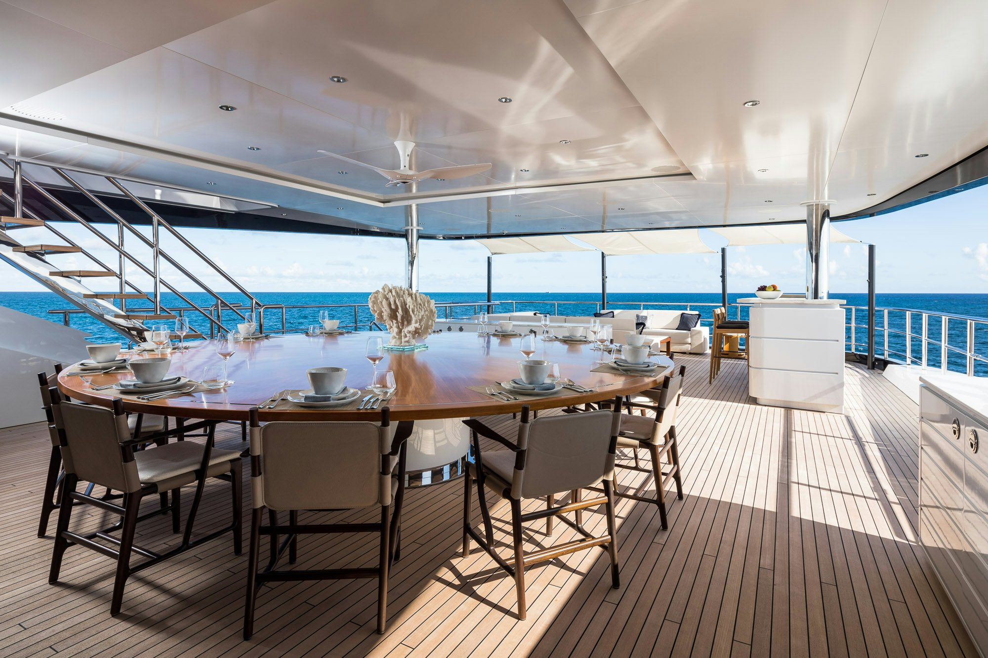 a large modern kitchen with a large table and chairs aboard CALEX Yacht for Charter