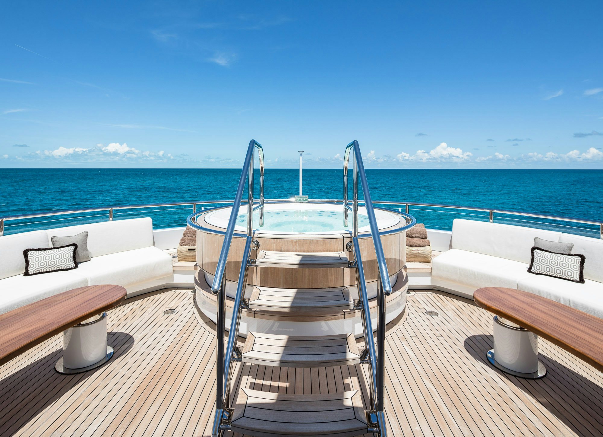 a deck with a bed and a large body of water aboard CALEX Yacht for Charter
