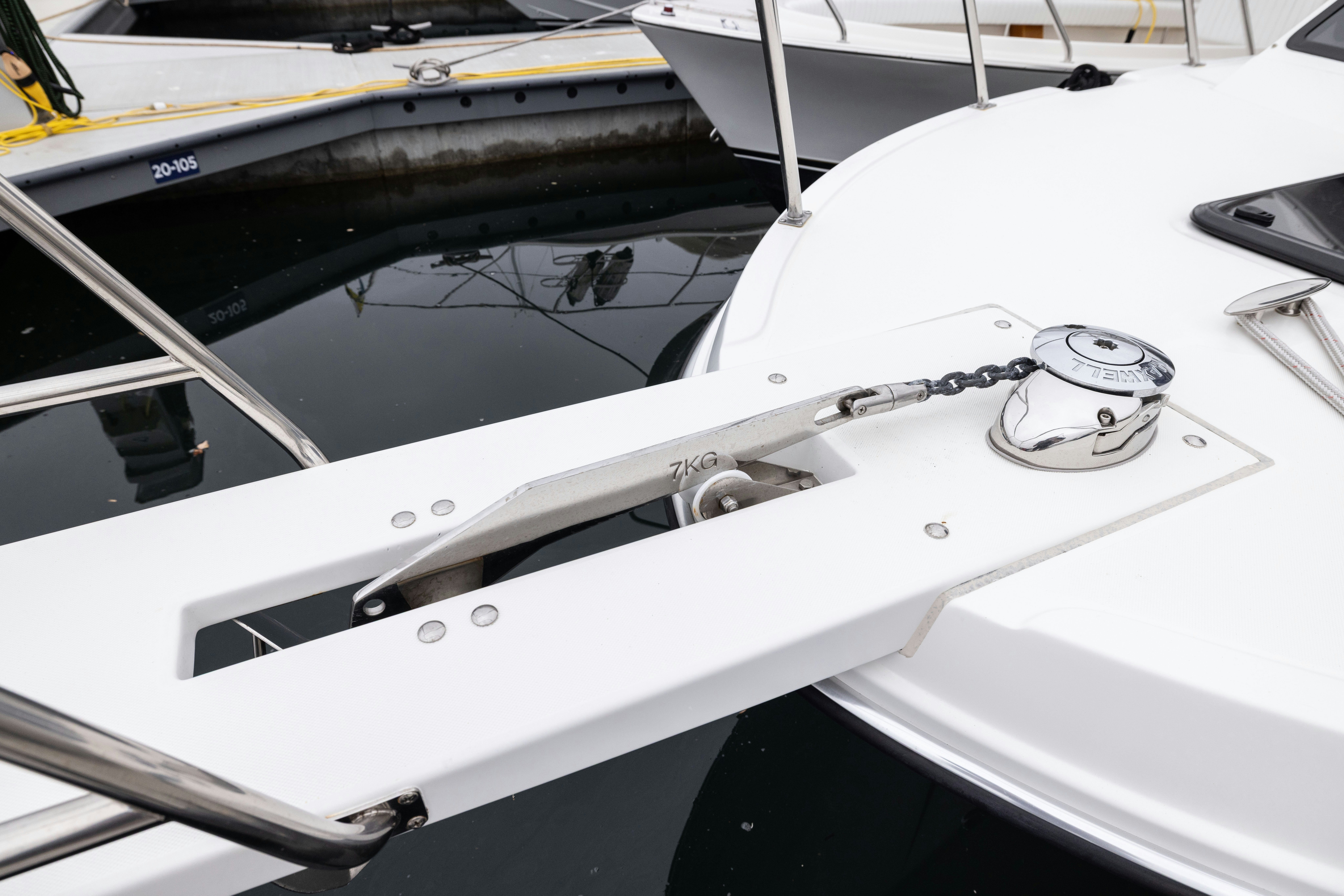 a white boat with a black and yellow sail aboard 5TH KID Yacht for Sale