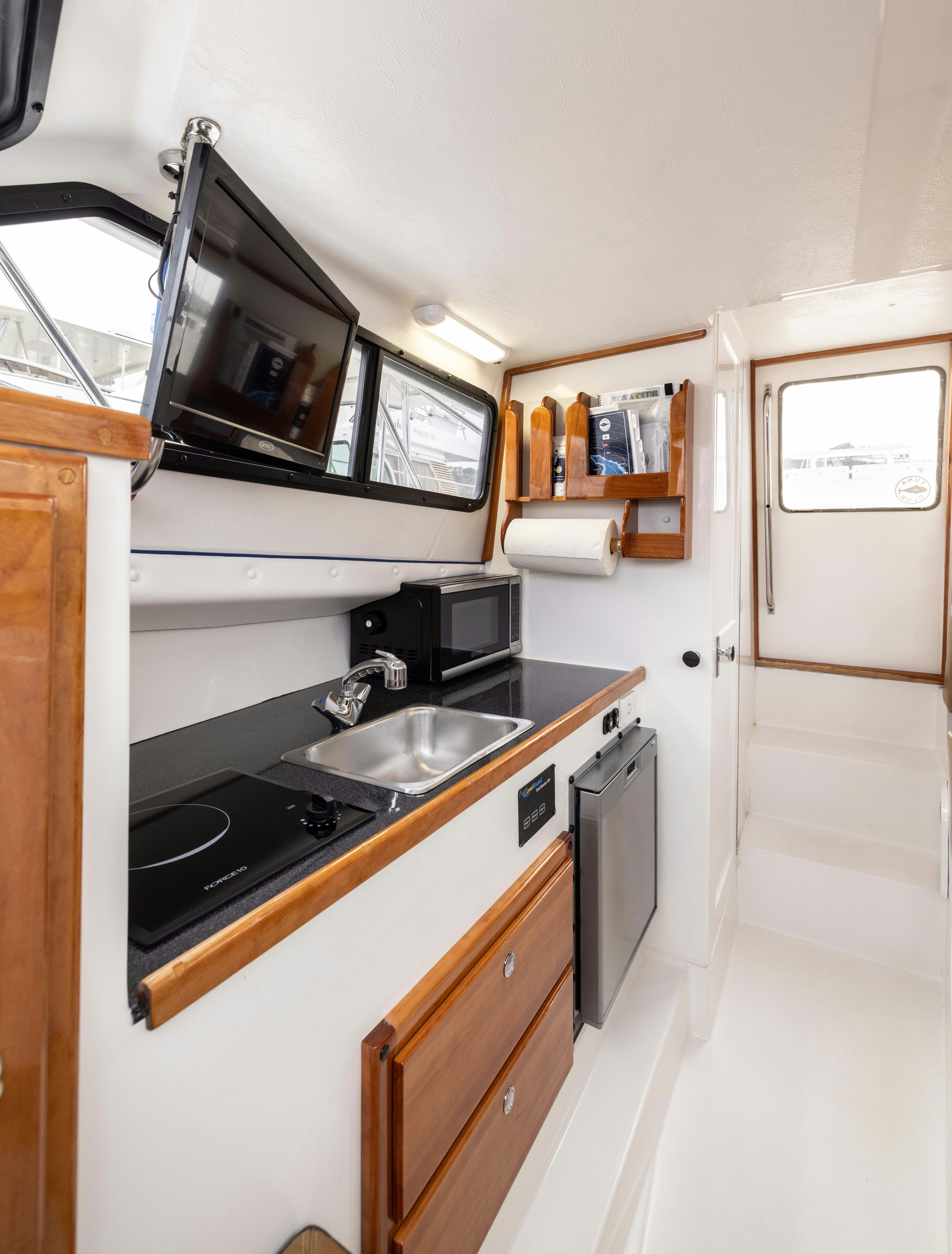 a kitchen with a stove and a microwave aboard 5TH KID Yacht for Sale