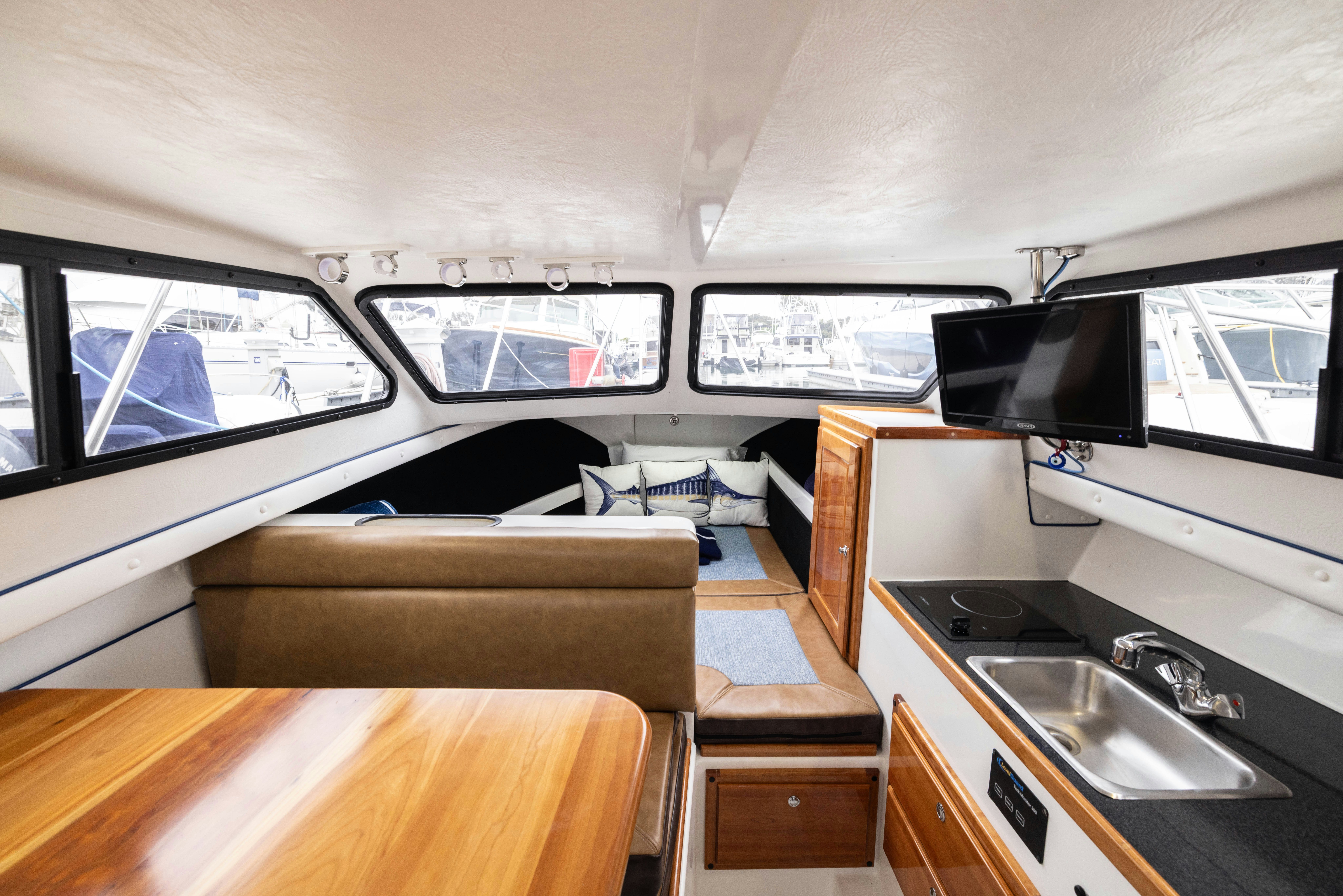 a small living room with a large tv and a large window aboard 5TH KID Yacht for Sale