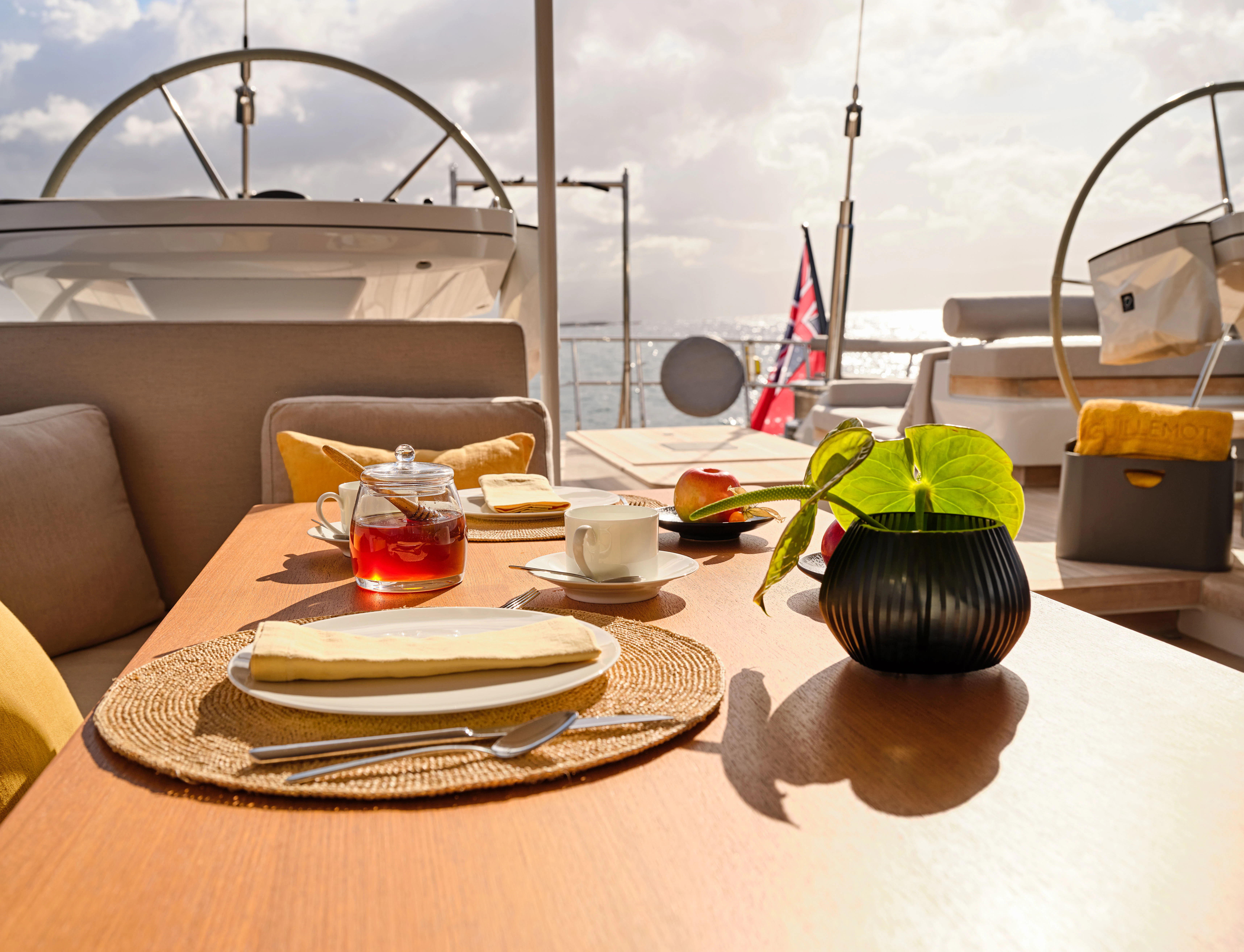 a table with plates and cups aboard GUILLEMOT Yacht for Charter