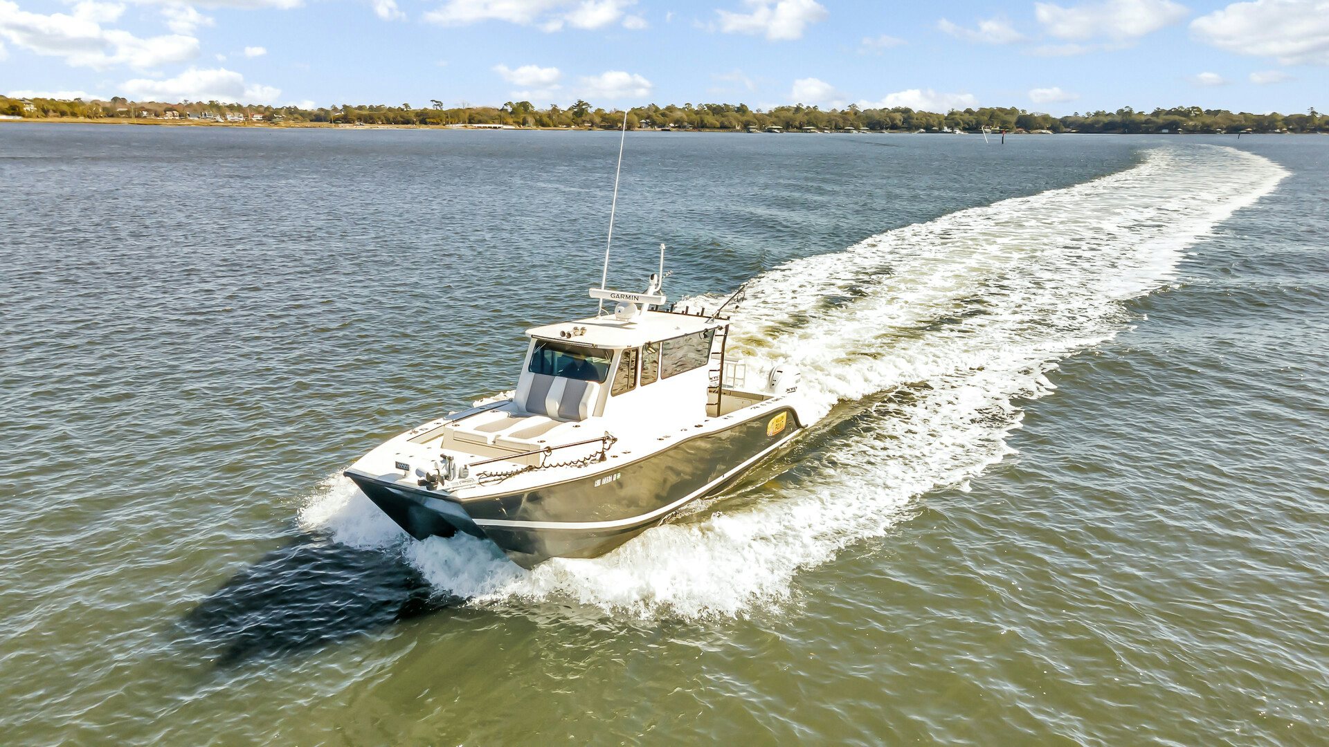 a boat driving on a body of water aboard OUR TRADE Yacht for Sale