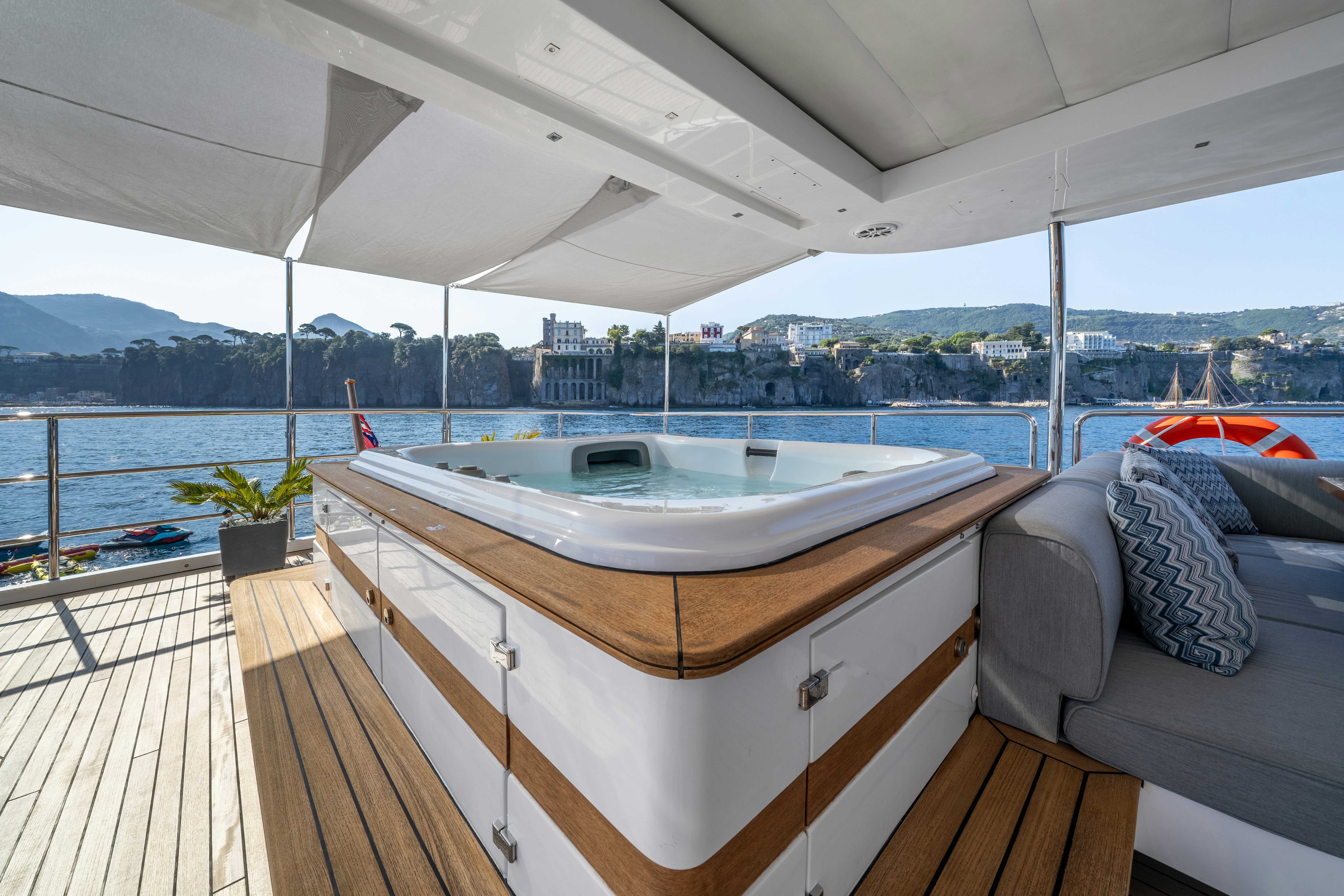 a large white bed on a deck overlooking a city aboard HORIZON Yacht for Sale