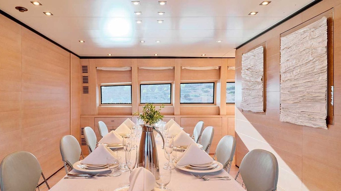 a table with plates and chairs aboard AMICI PER SEMPRE Yacht for Charter