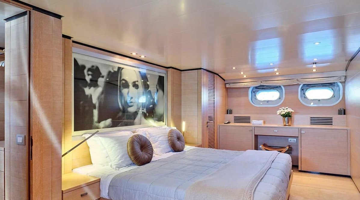 a room with a bed and a painting on the wall aboard AMICI PER SEMPRE Yacht for Charter
