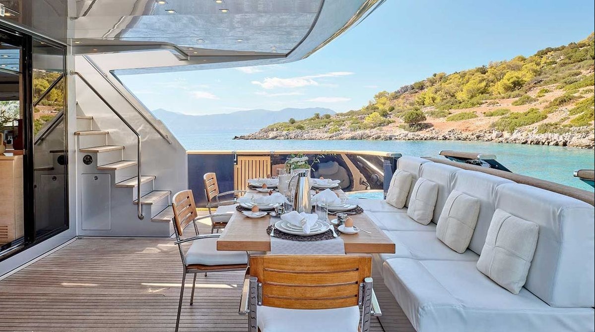 a table on a deck overlooking a body of water aboard AMICI PER SEMPRE Yacht for Charter