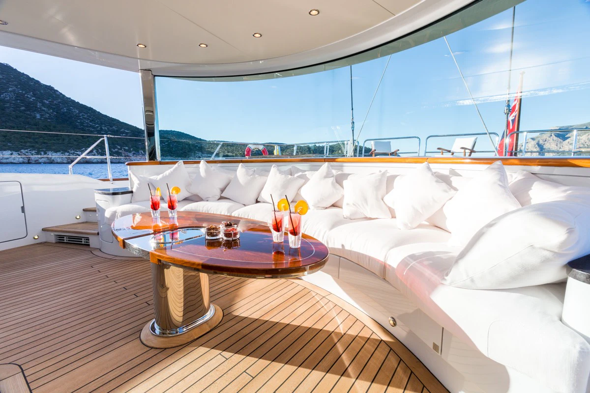 a bed with a table and candles aboard Q Yacht for Charter