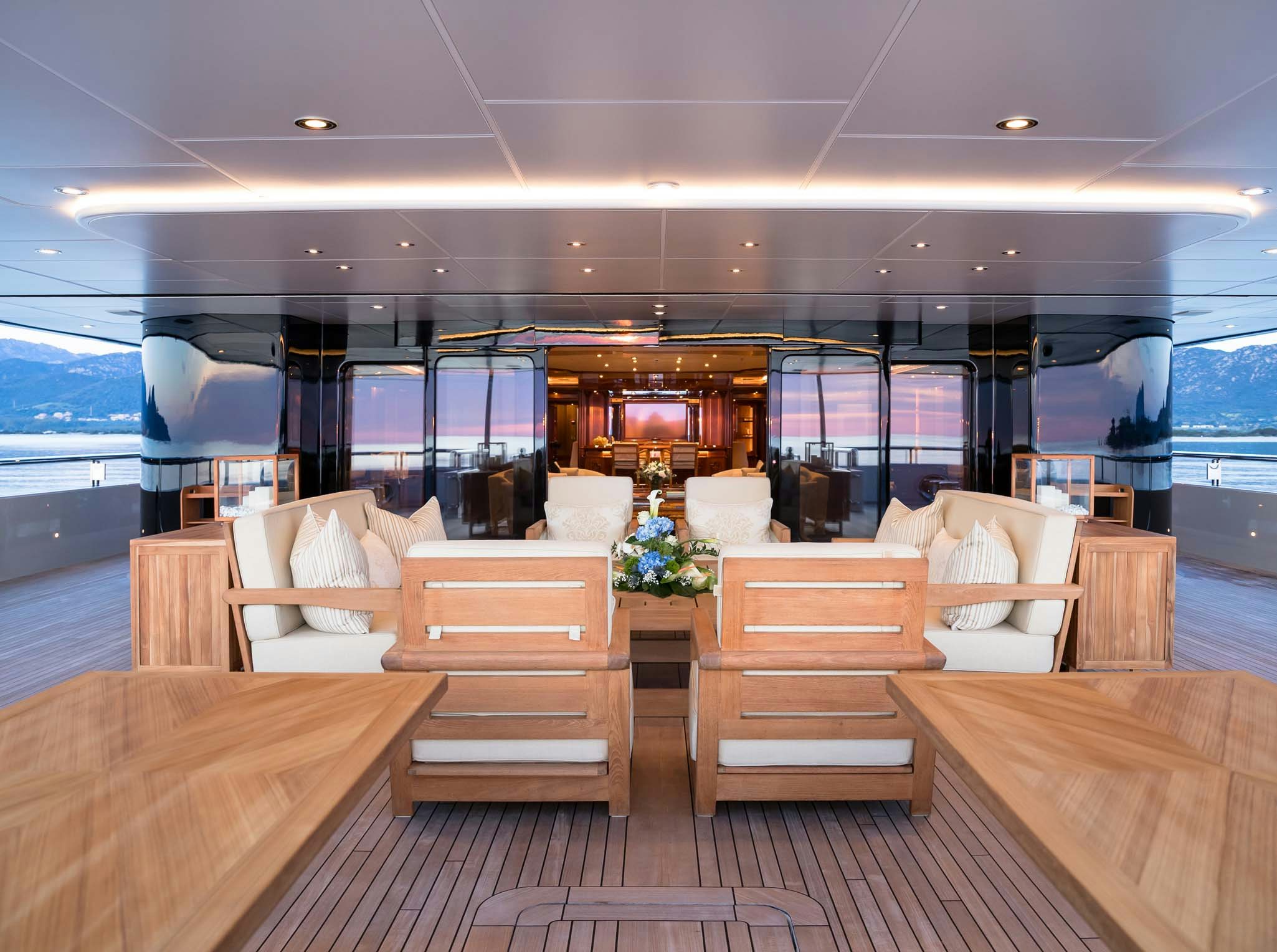 a room with a wood floor and a large window with a view of the ocean aboard STARFIRE Yacht for Charter