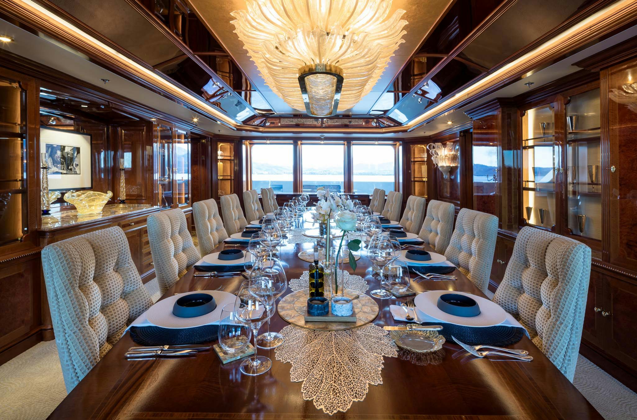 a large dining room with a large chandelier aboard STARFIRE Yacht for Charter