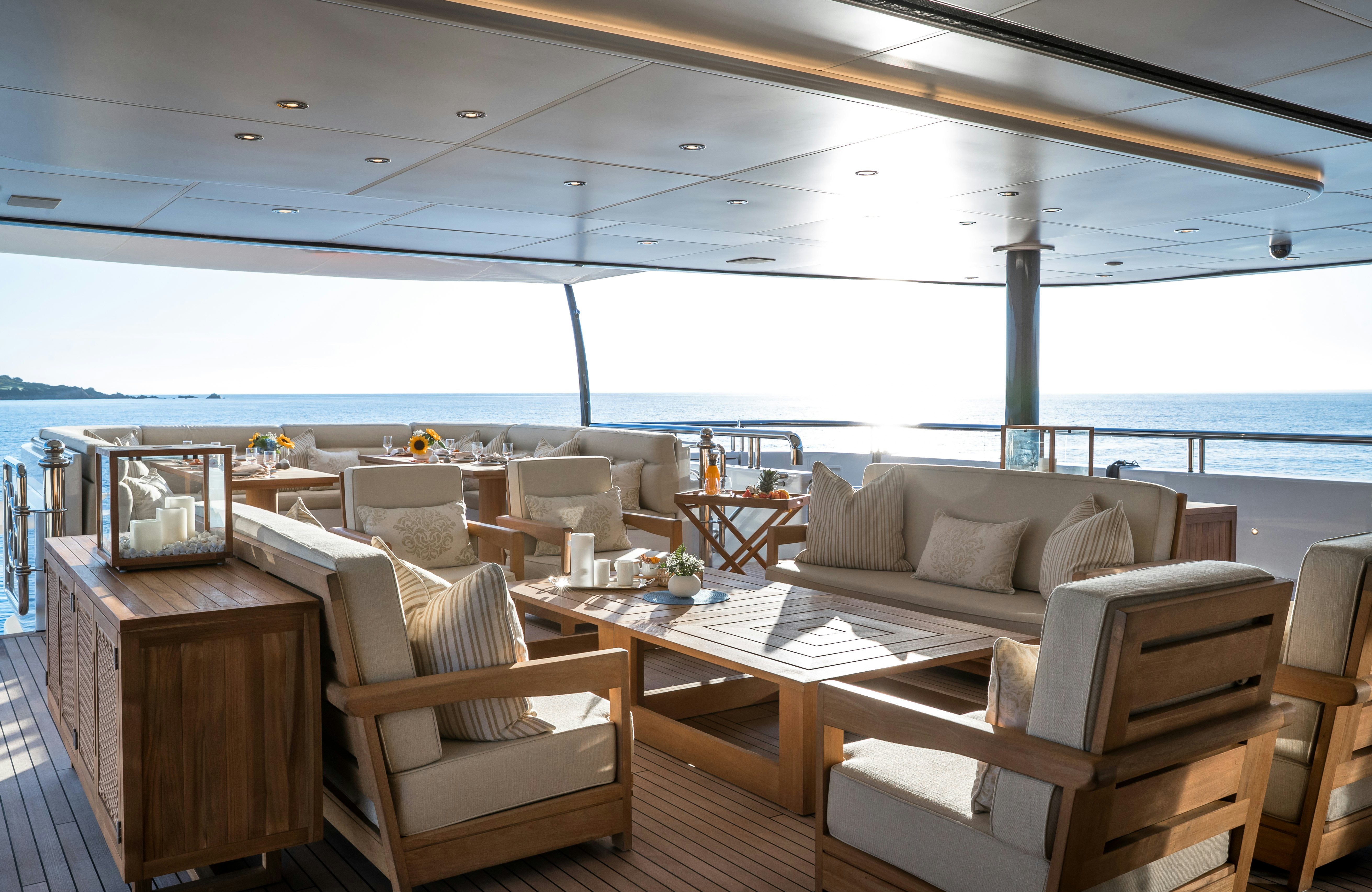 a room with a table chairs and a view of the ocean aboard STARFIRE Yacht for Charter