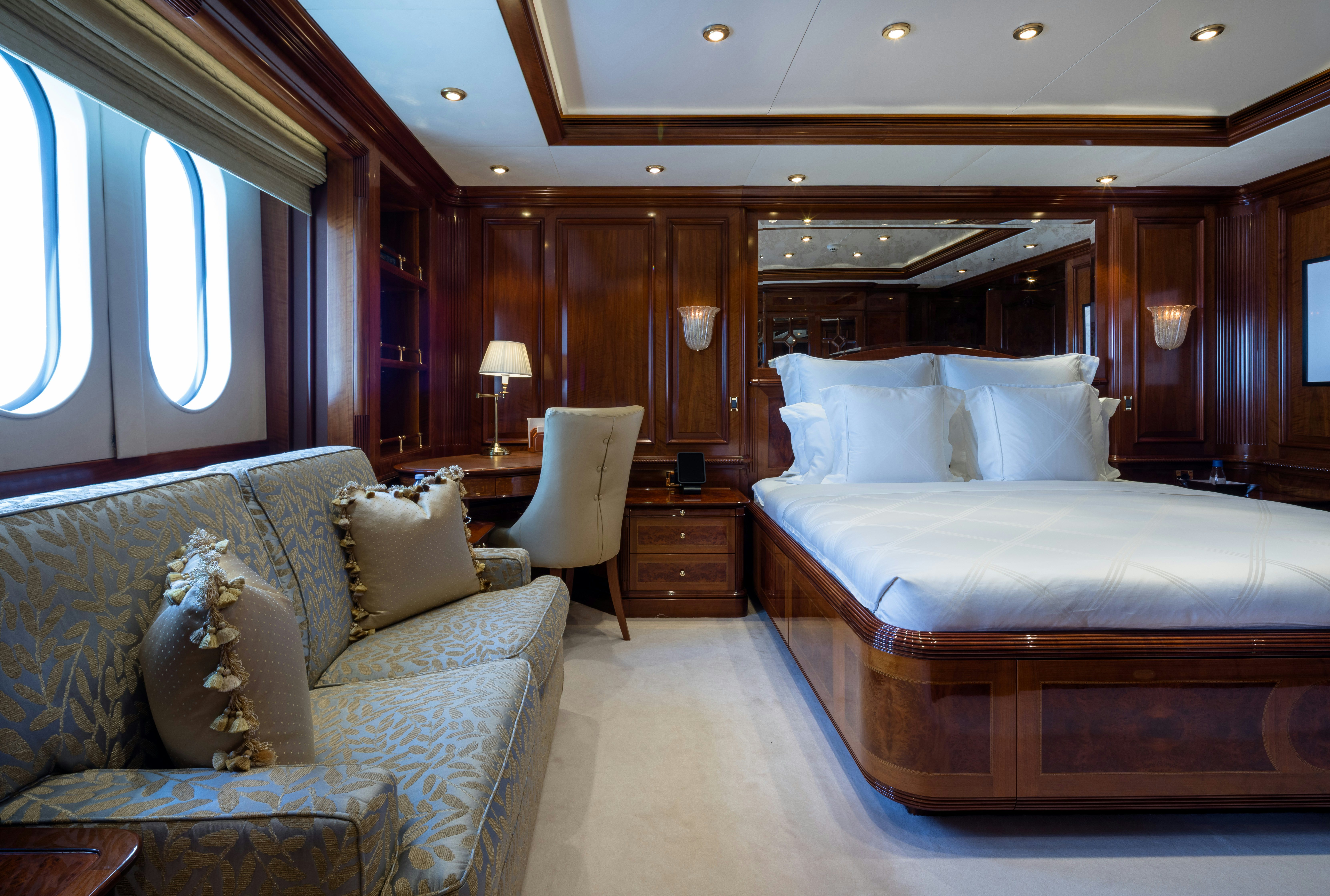 a bedroom with a bed and a couch aboard STARFIRE Yacht for Charter